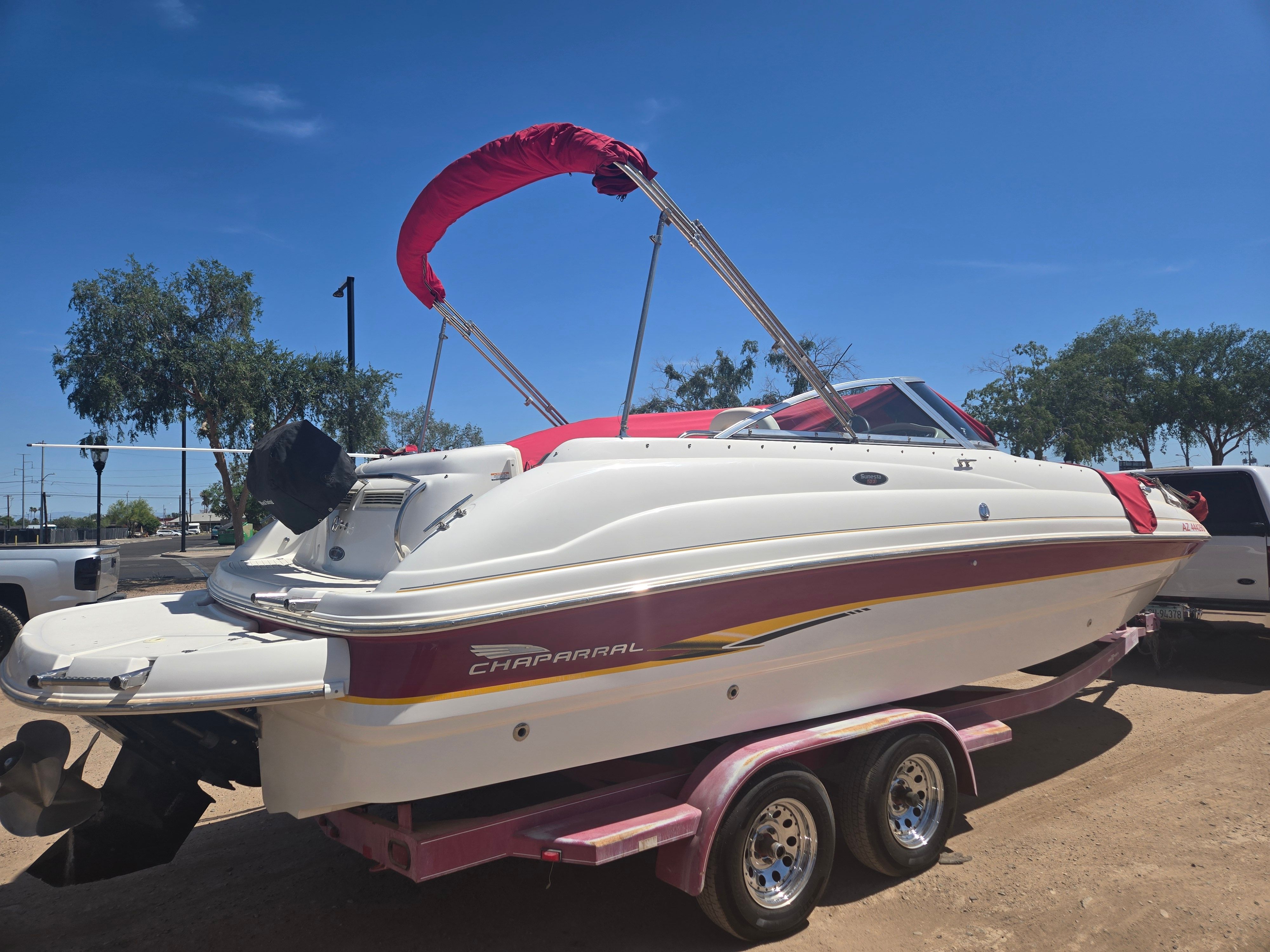 2001 Chaparral Sunesta 233 boat on trailer, red canopy, sunny day.