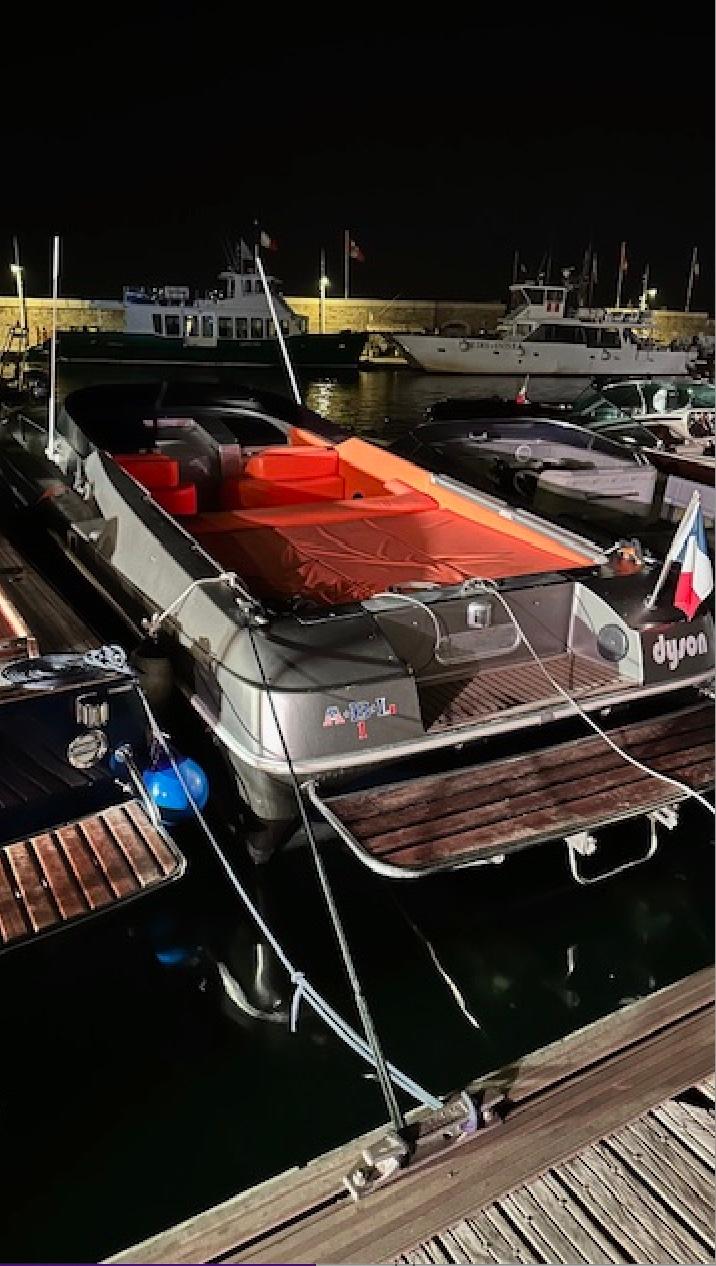 1991 Tullio Abbate Superiority 41 boat docked at night, featuring sleek design and vibrant seating.
