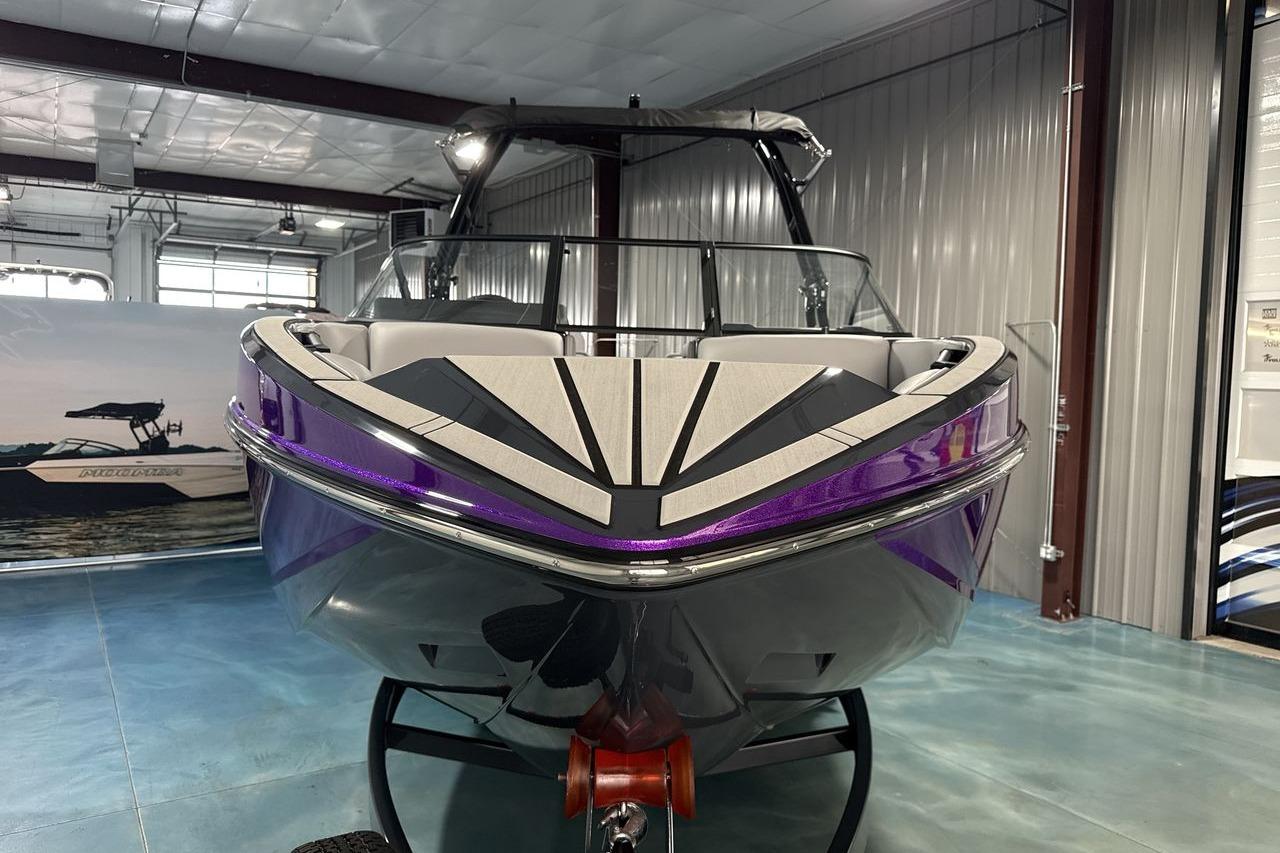 A modern 2026 Moomba Craz in a showroom, featuring a sleek design with purple accents.