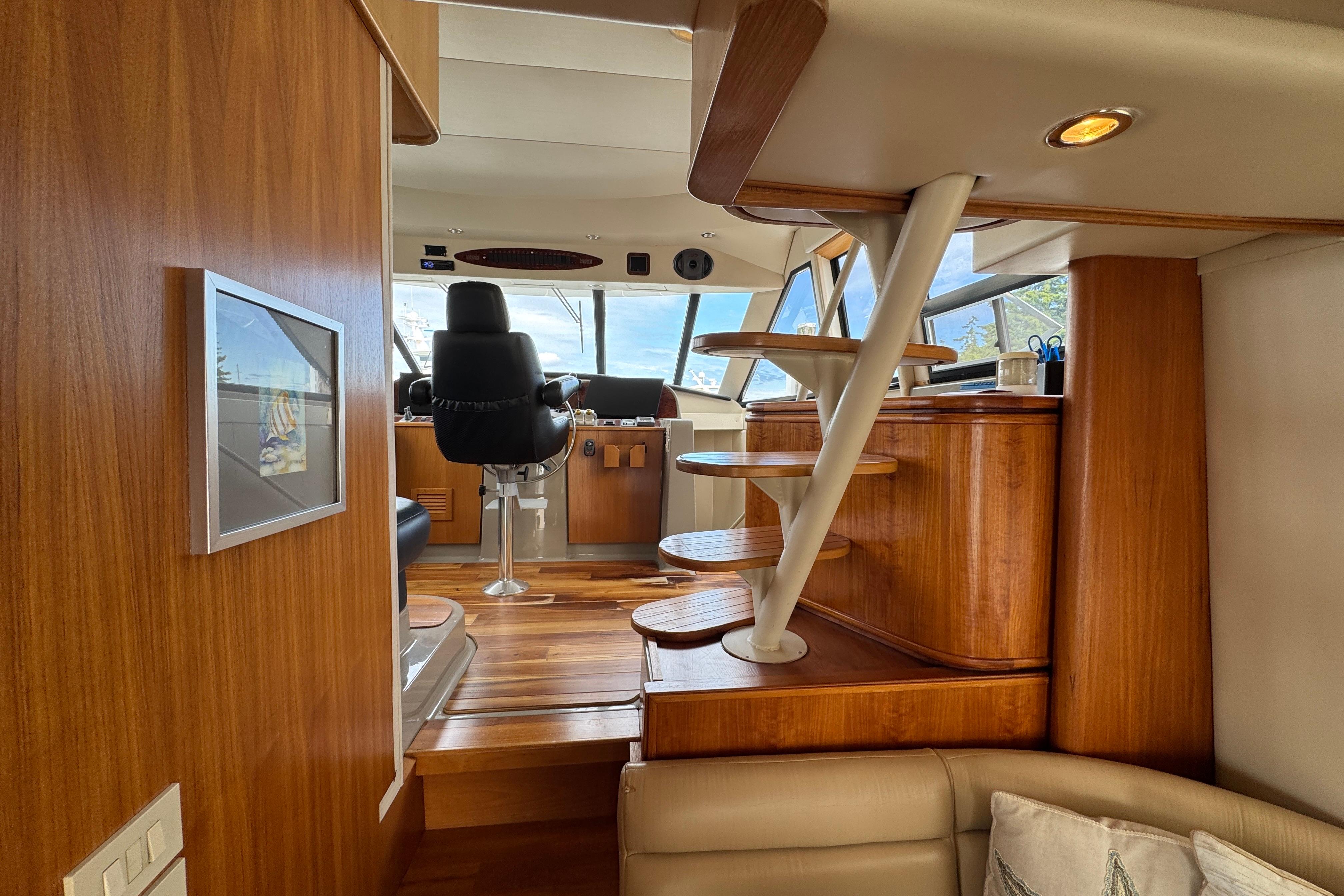 1998 Bayliner 5788 Pilot House Motoryacht interior with wooden stairs and captain's chair.