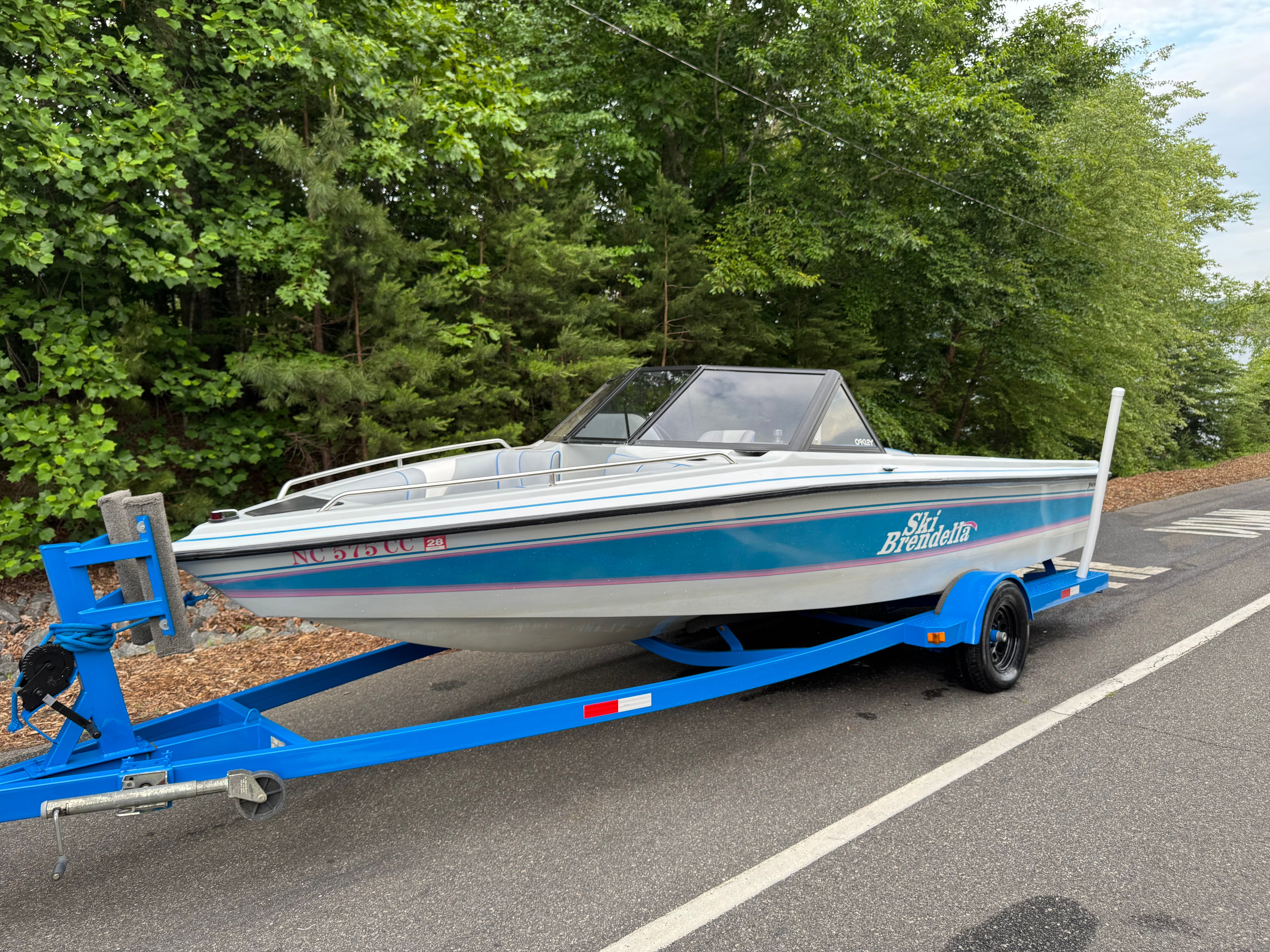 1992 Ski Brendella Spectrum on blue trailer, surrounded by trees.