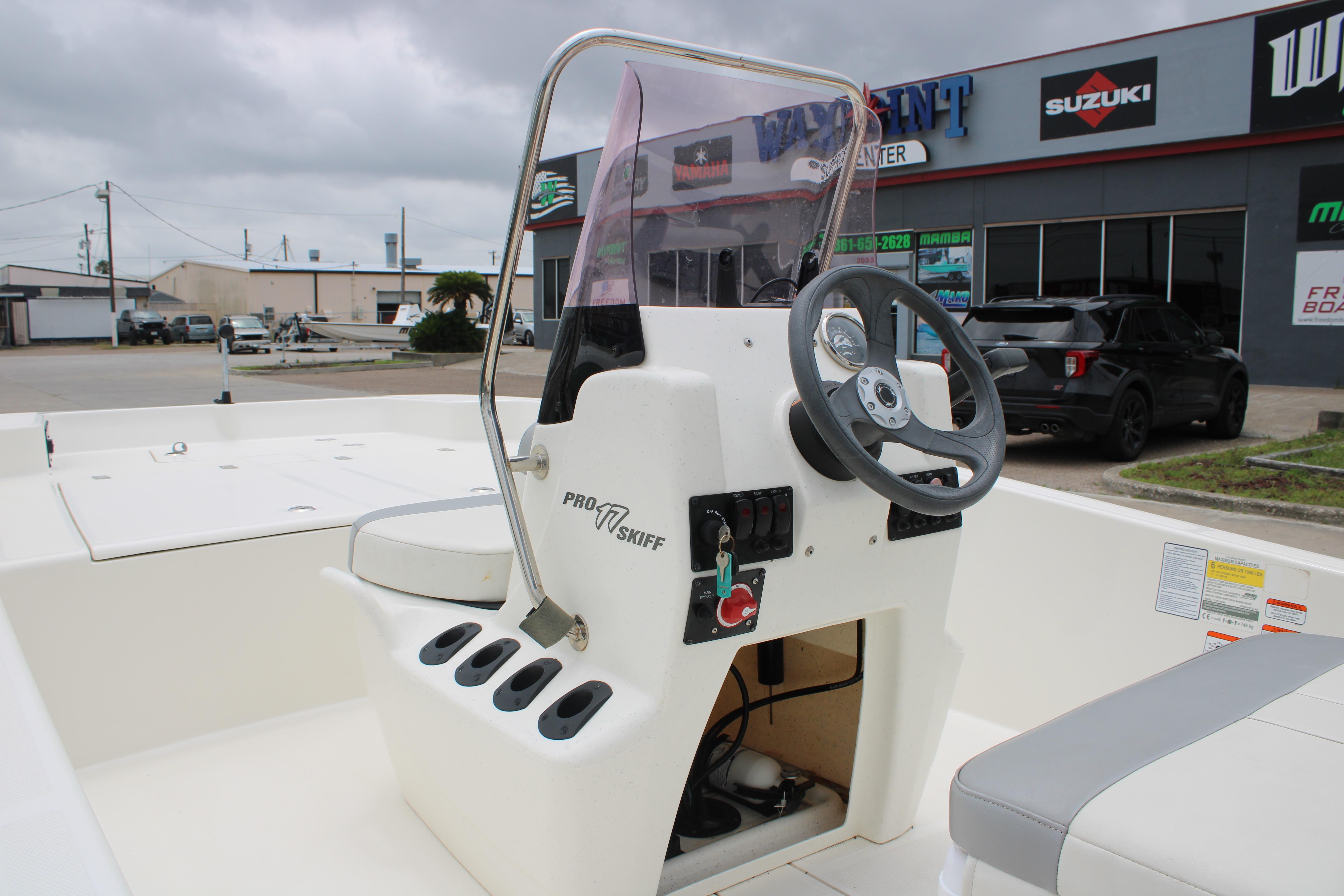 2021 Mako Pro Skiff 17 CC boat console with steering wheel and controls, parked outdoors.