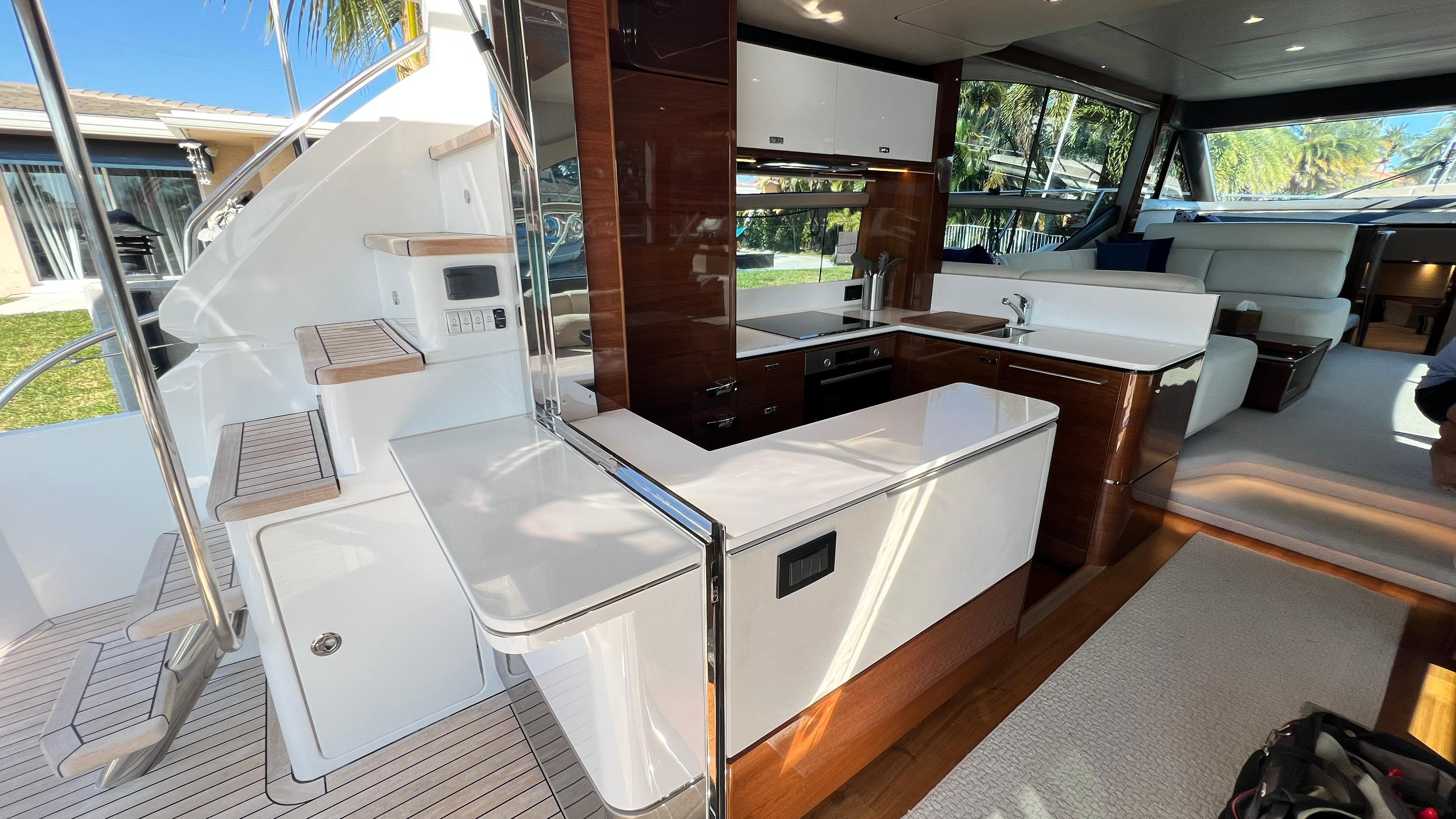 Luxurious interior of 2019 Princess F62 yacht with modern kitchen and seating area.