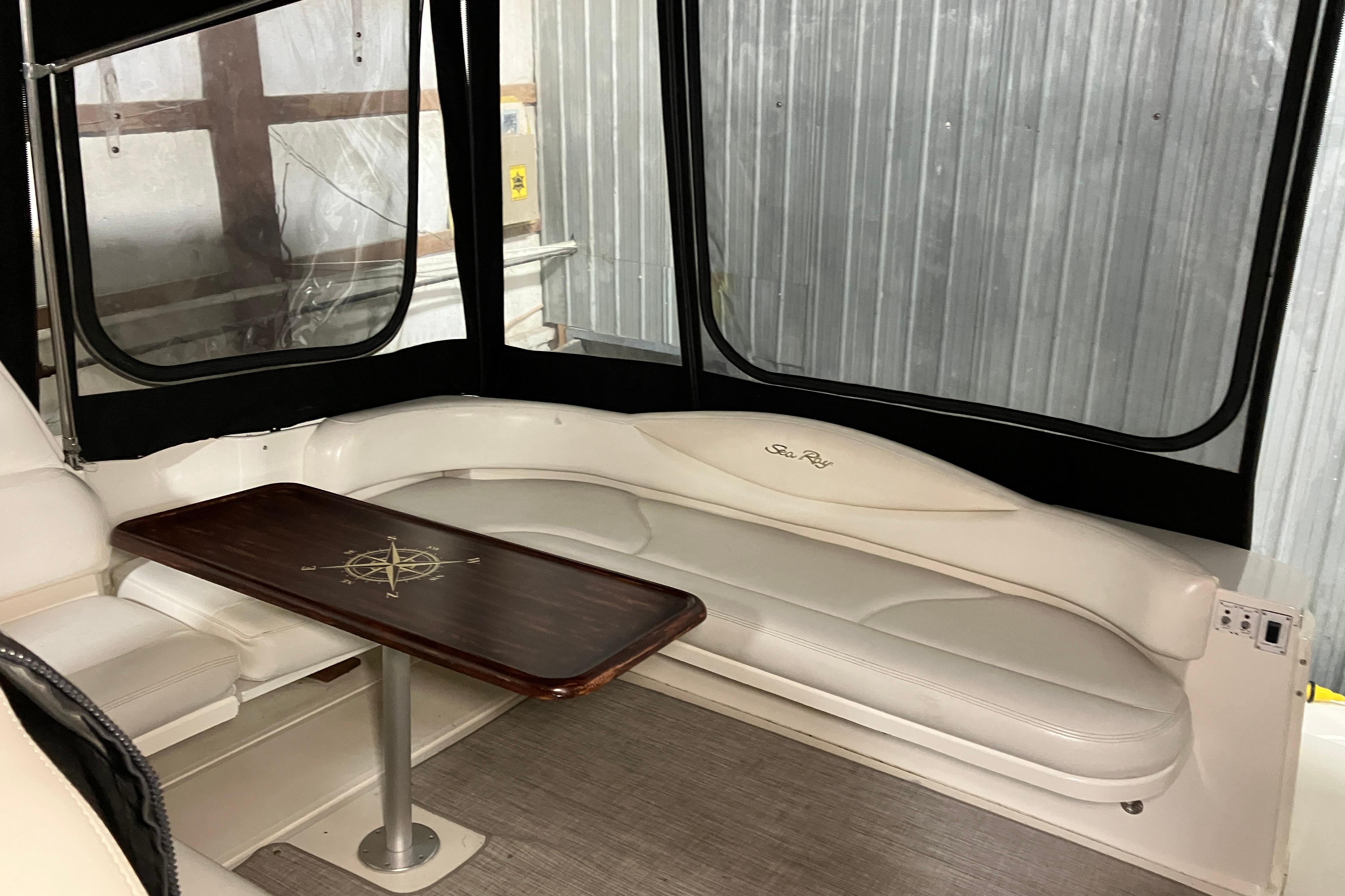 Interior of 2002 Sea Ray 410 Sundancer with white seating and wooden table.