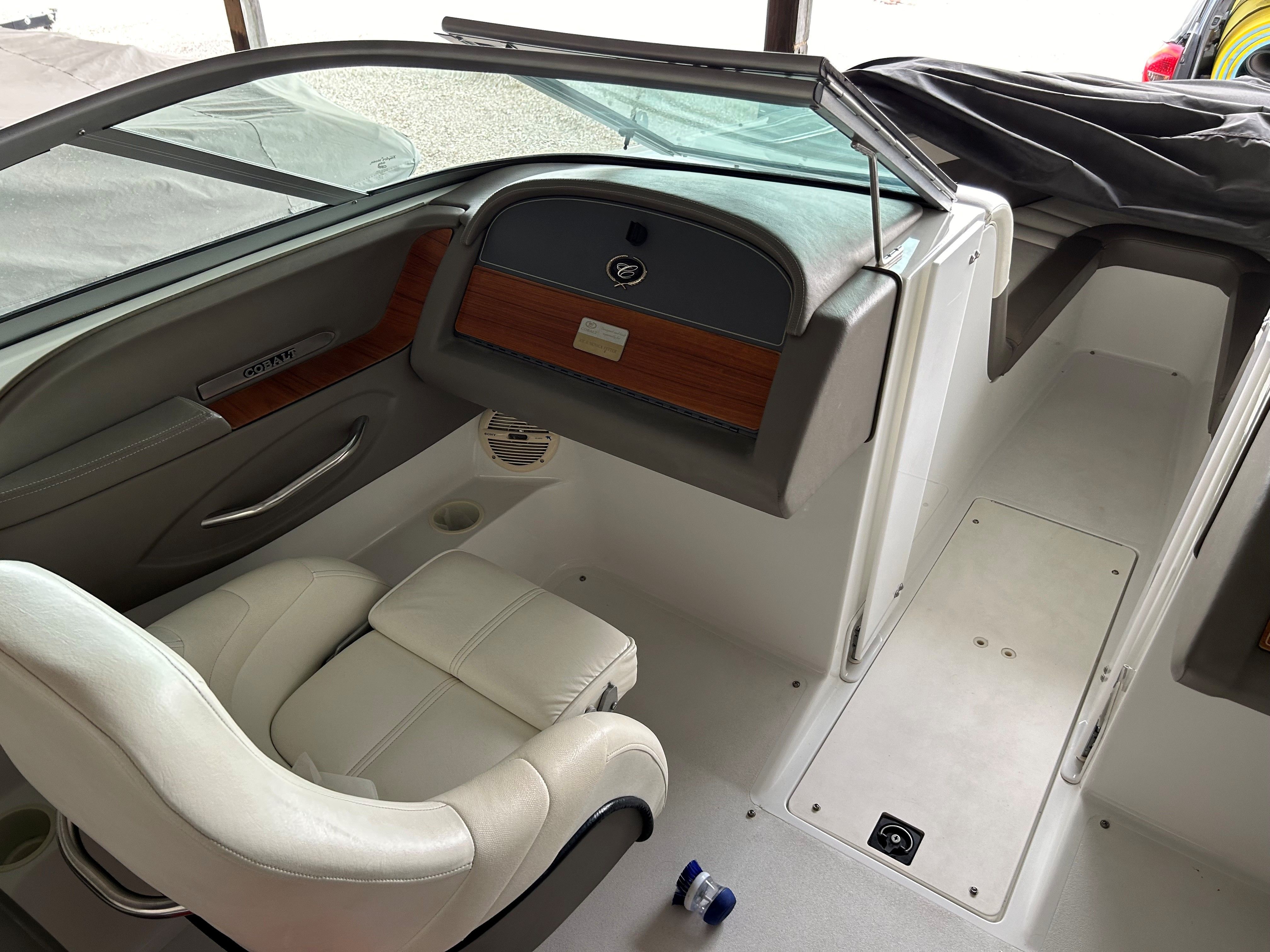 Interior of a Cobalt 226 boat with white seats and wood paneling.