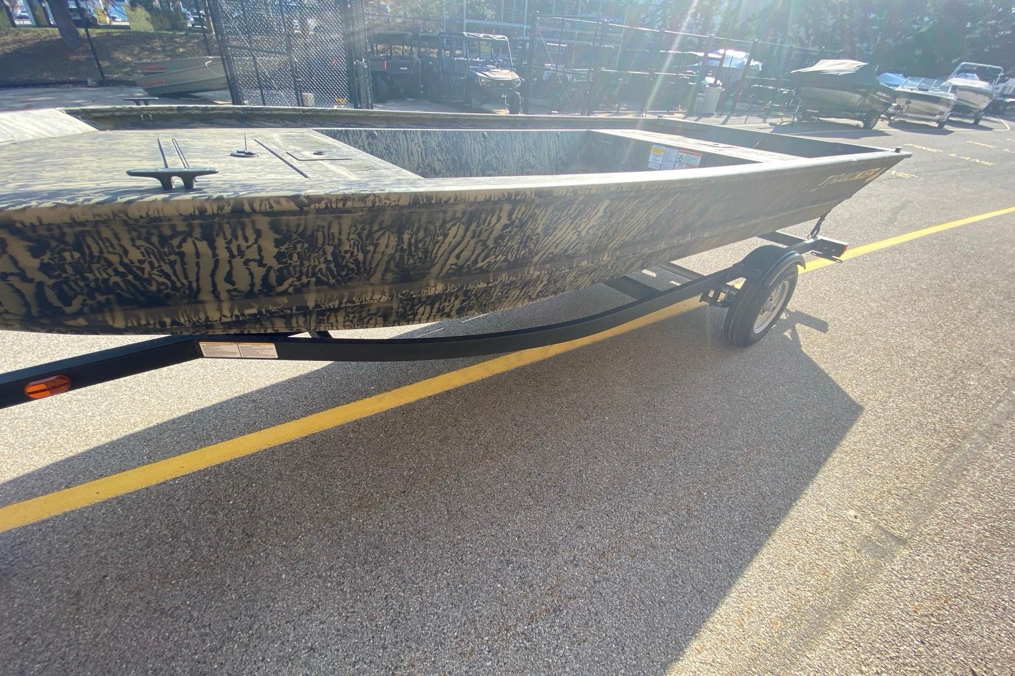 2026 Tracker Grizzly 1648 Utility boat on trailer, camo design, parked outdoors.