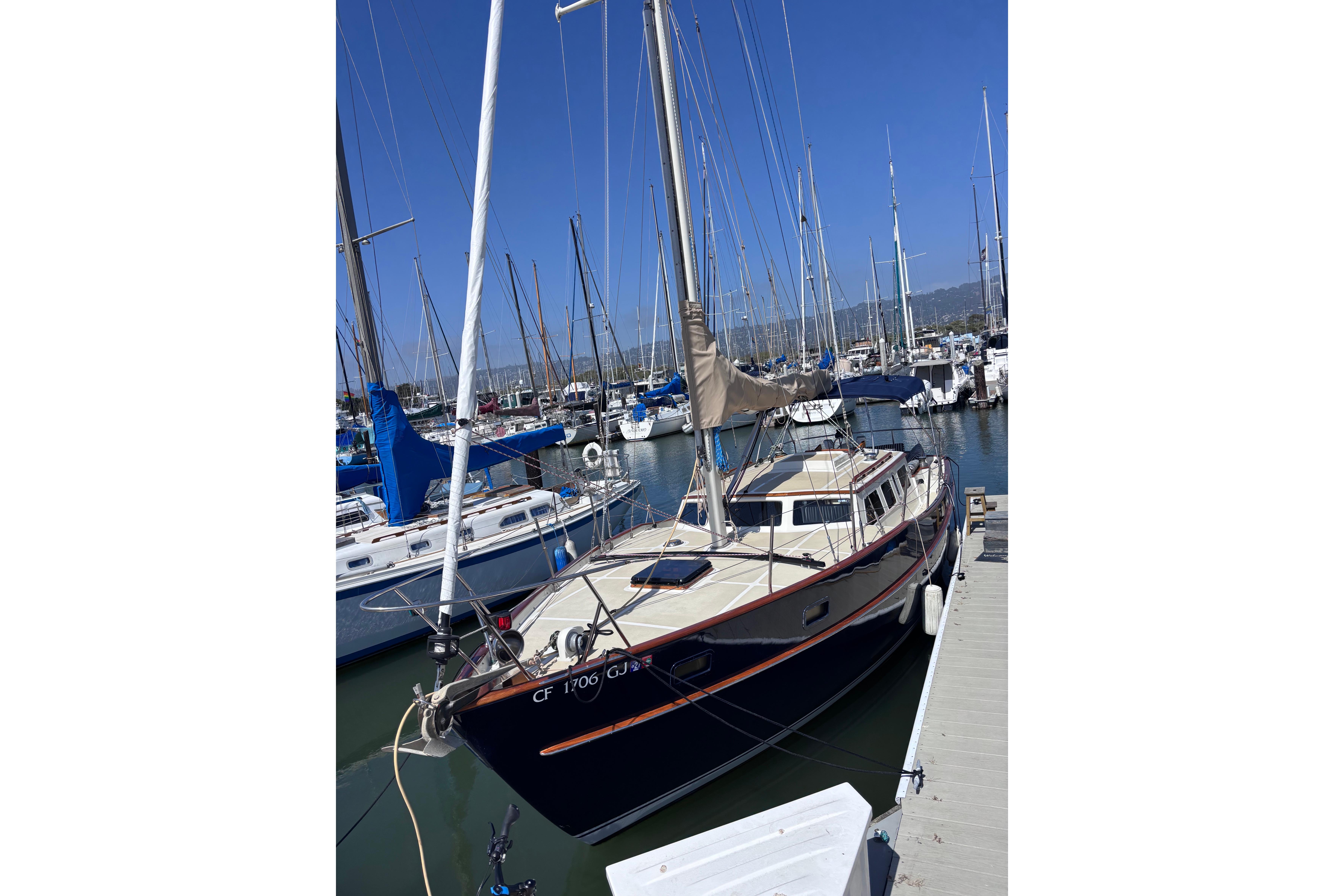 1978 Swift 33 sailboat docked in a marina under clear blue skies.