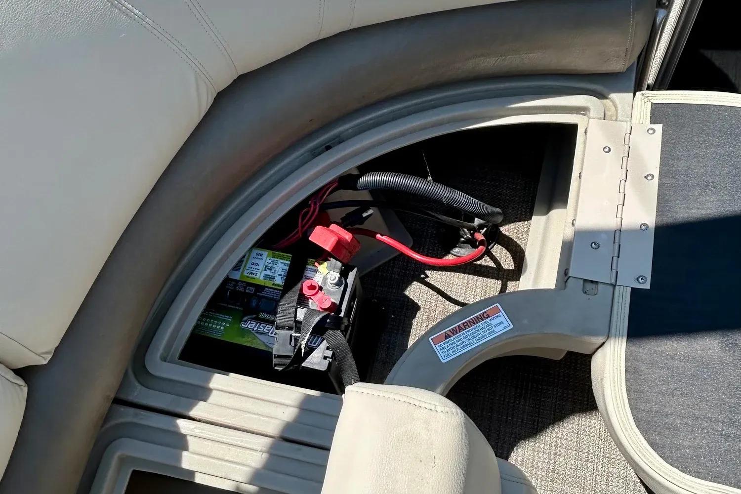 2017 Starcraft CX 23 RE boat battery compartment with wiring and warning label.