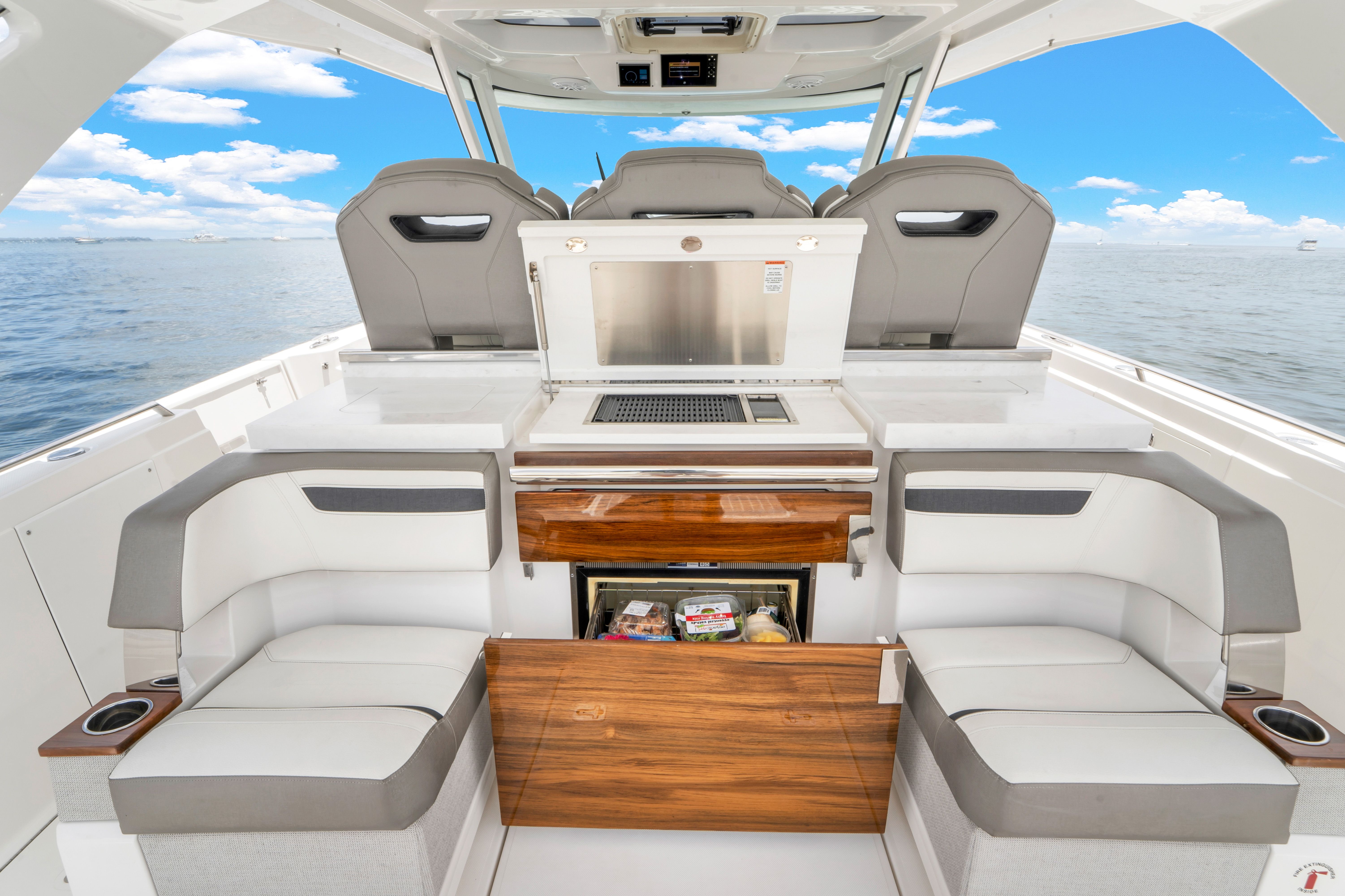 The image shows the cockpit of a 2023 Tiara Yachts 38 LS with luxurious seating.
