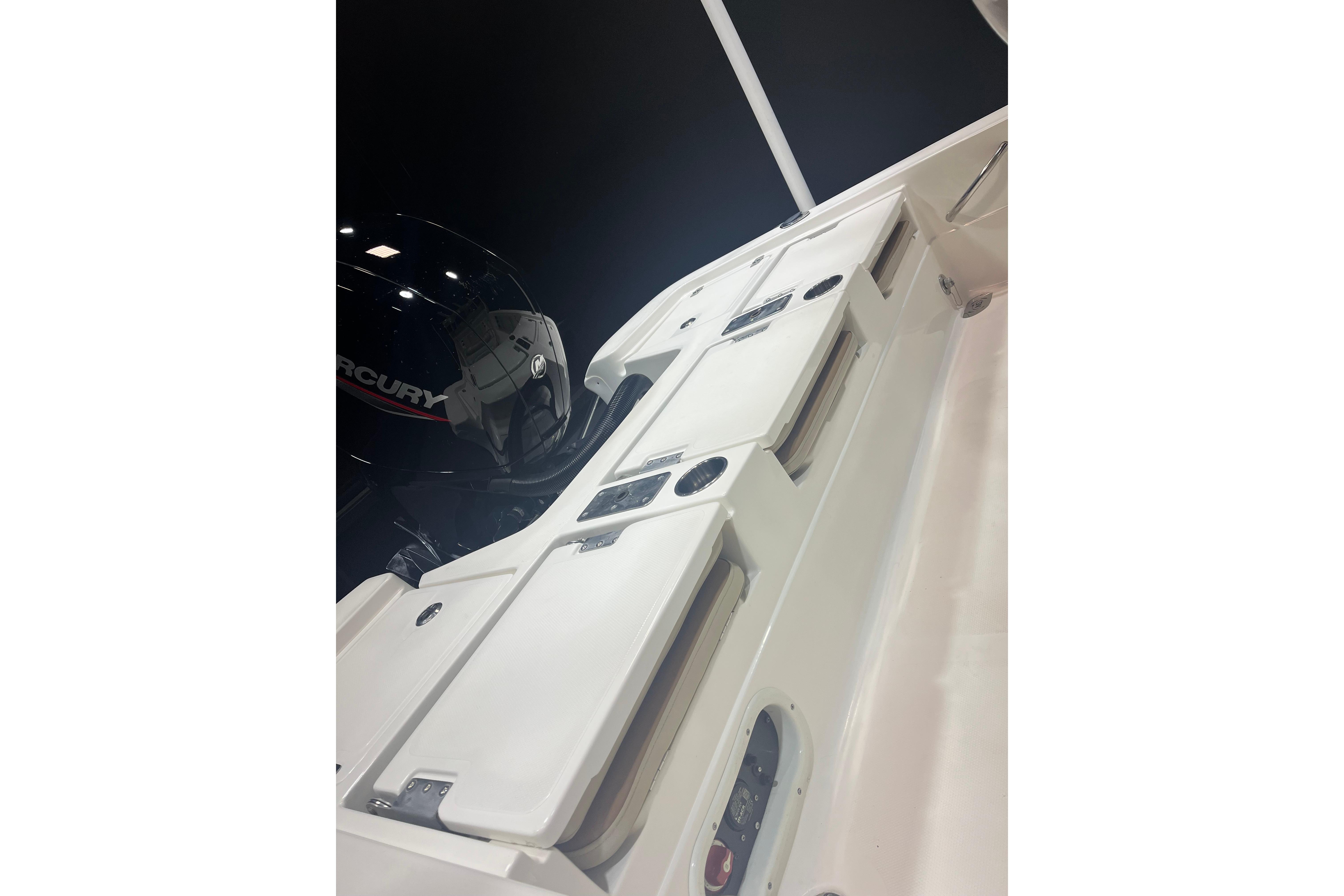 2023 NauticStar 227 XTS boat with Mercury engine, showcasing sleek design and storage compartments.