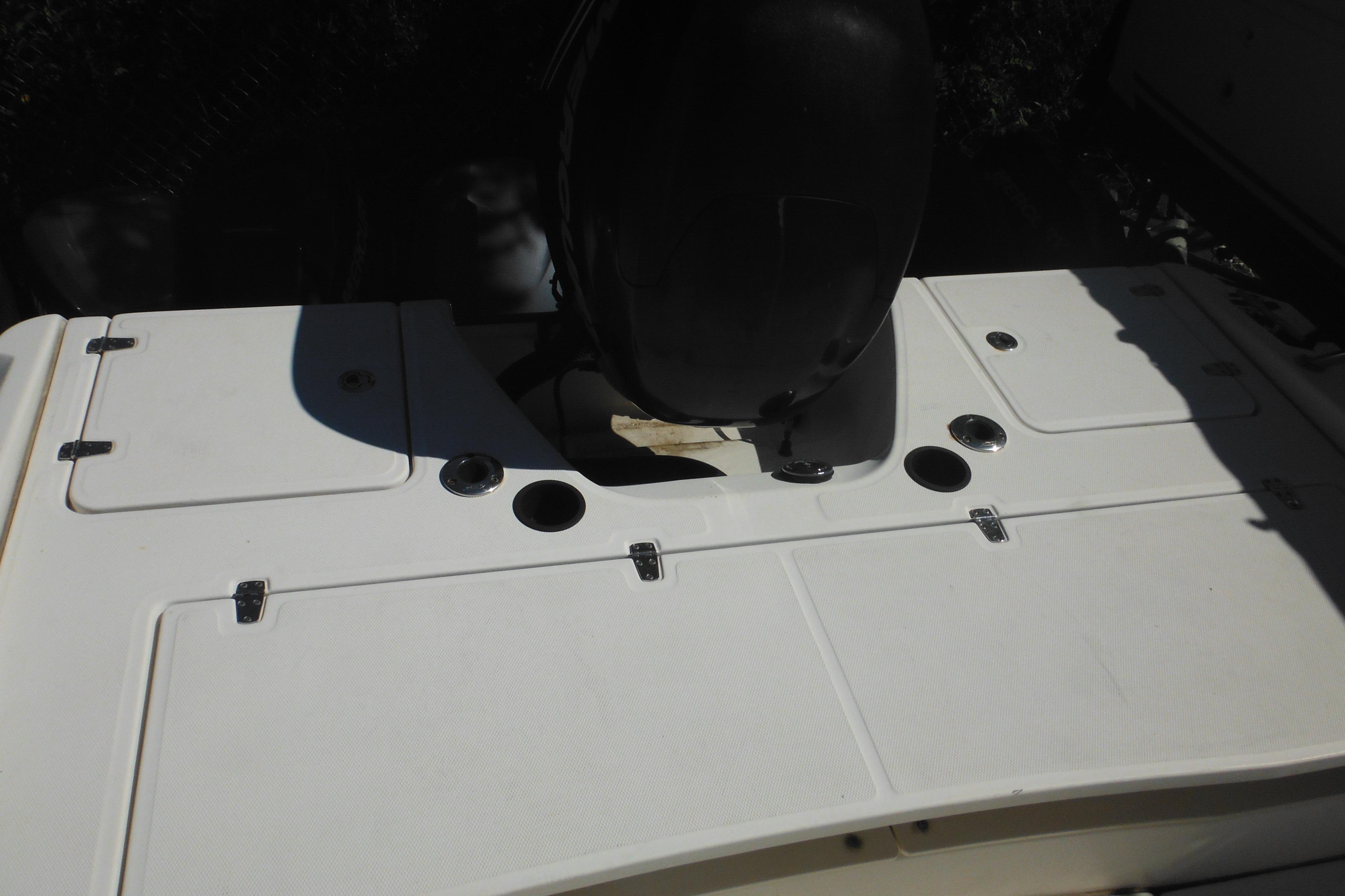 2009 Boston Whaler 200 Dauntless boat deck with storage compartments and motor.