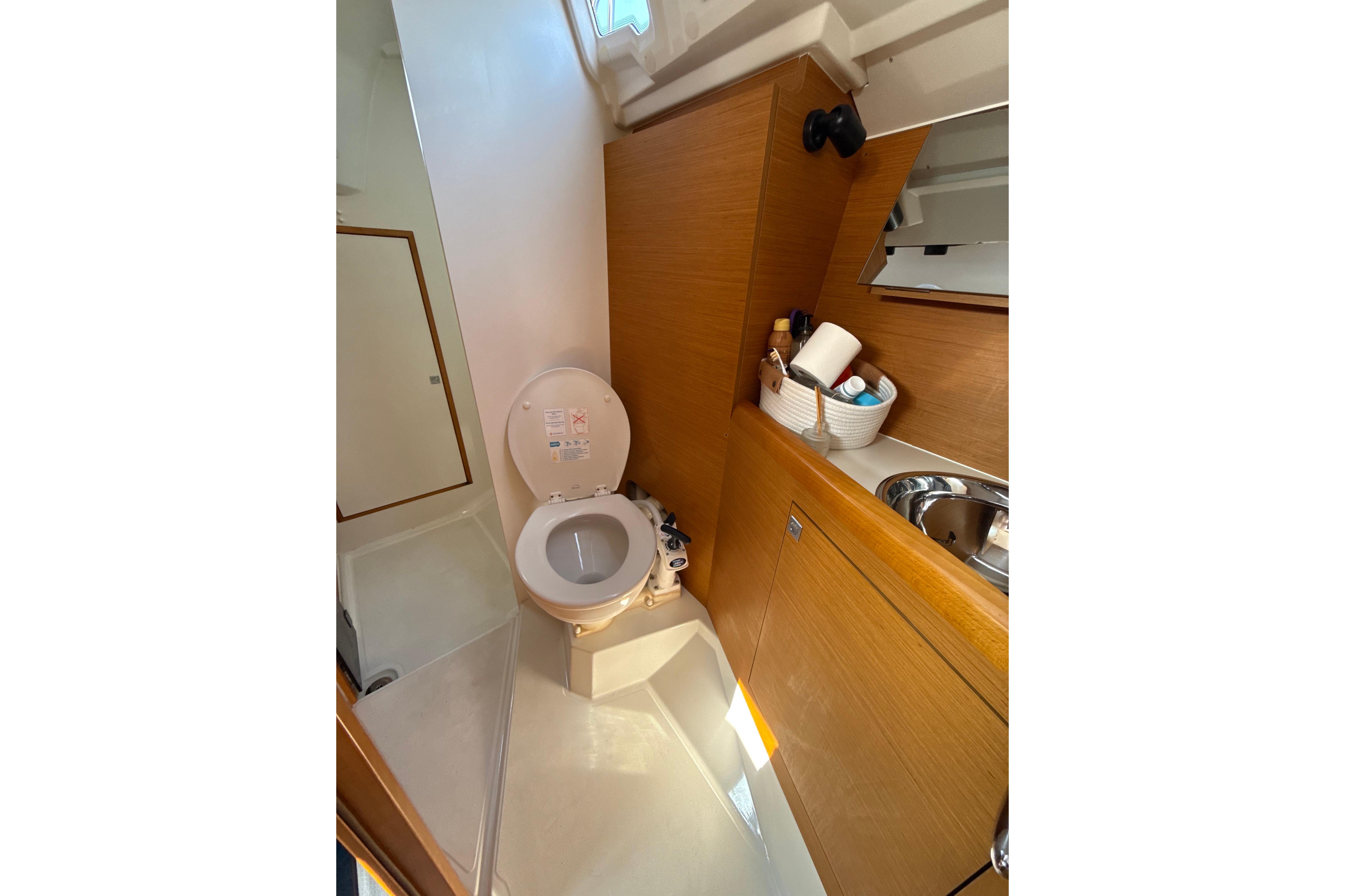 Bathroom interior of 2016 Jeanneau Sun Odyssey 349 yacht, featuring toilet and sink.
