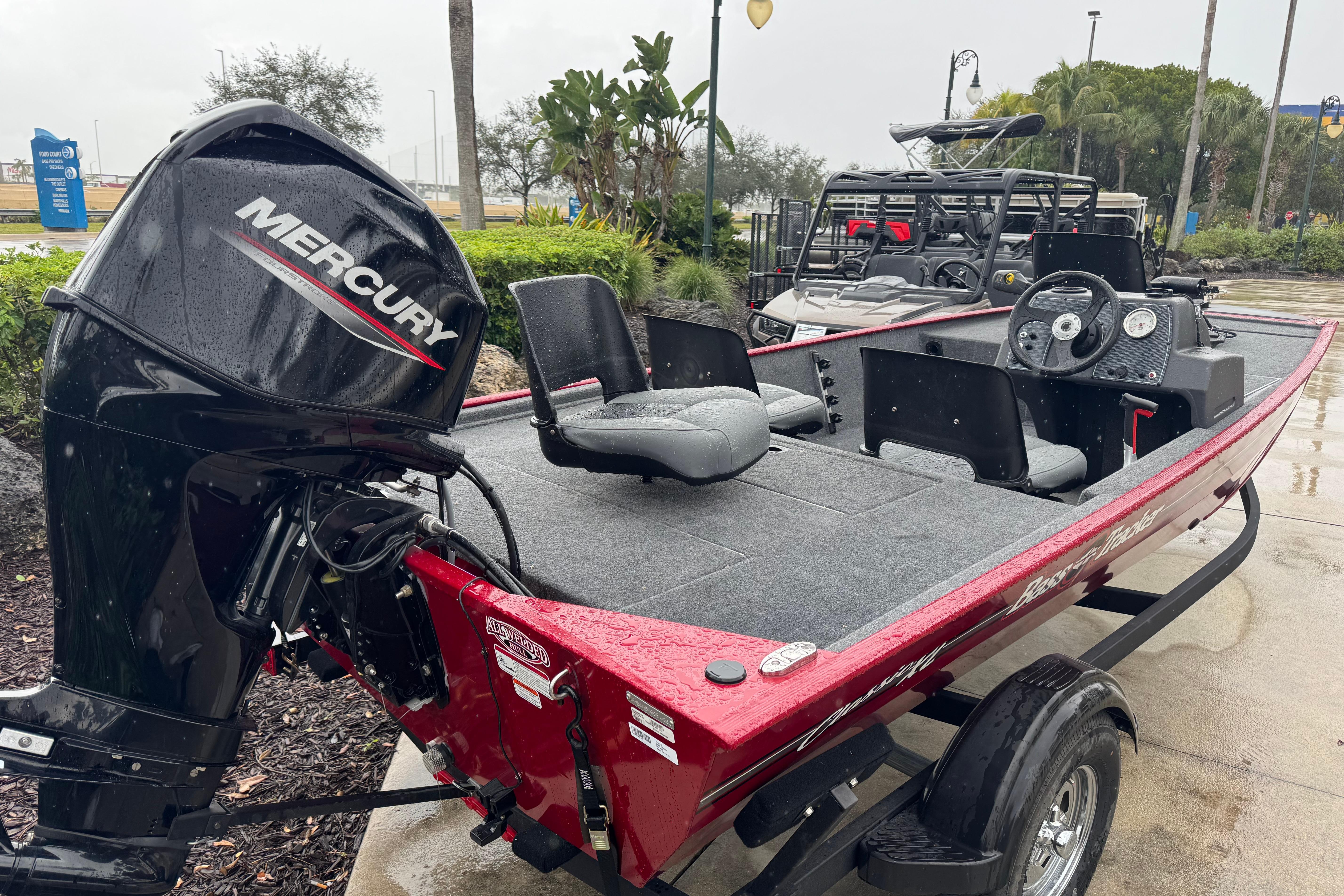 2025 Tracker Bass Tracker Classic XL boat with Mercury engine, parked outdoors on a rainy day.