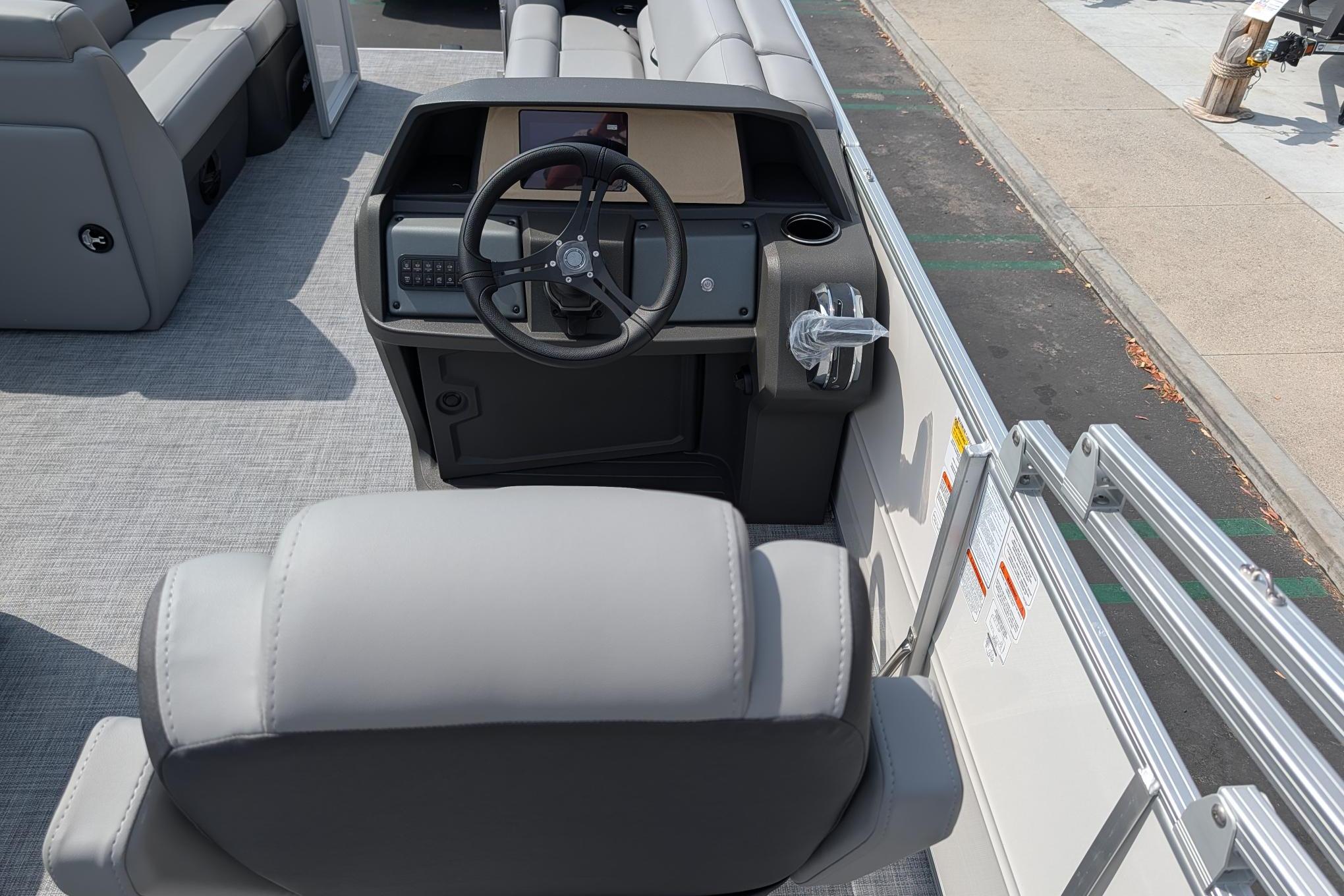 2026 Sun Tracker Party Barge 20 DLX helm with steering wheel and seating.