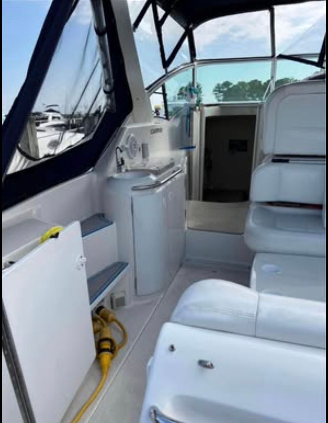 The image shows the cockpit of a 1996 Carver 310 with white seating and blue accents.