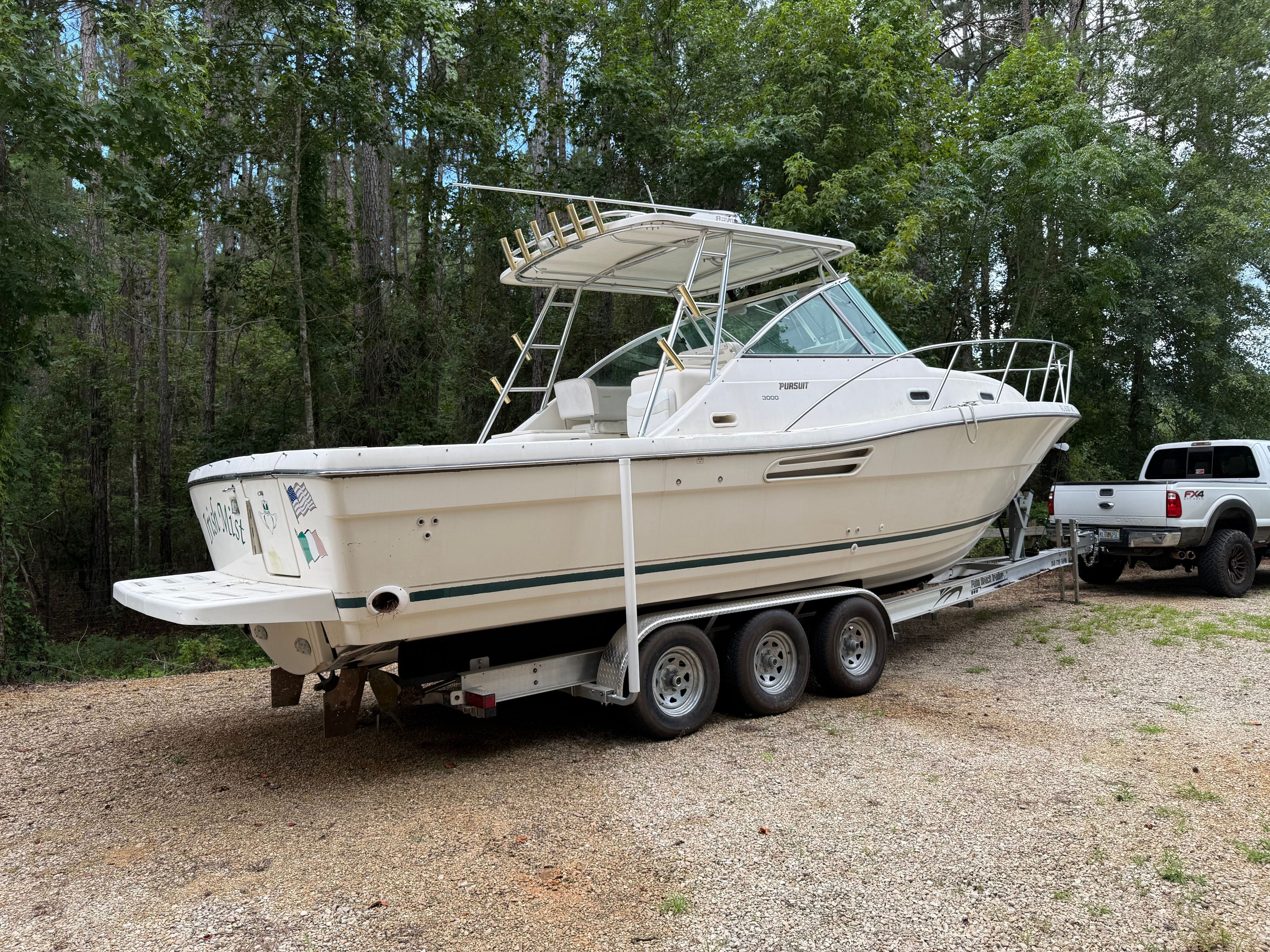 A 2002 Pursuit 3000 Express boat on a trailer outdoors.