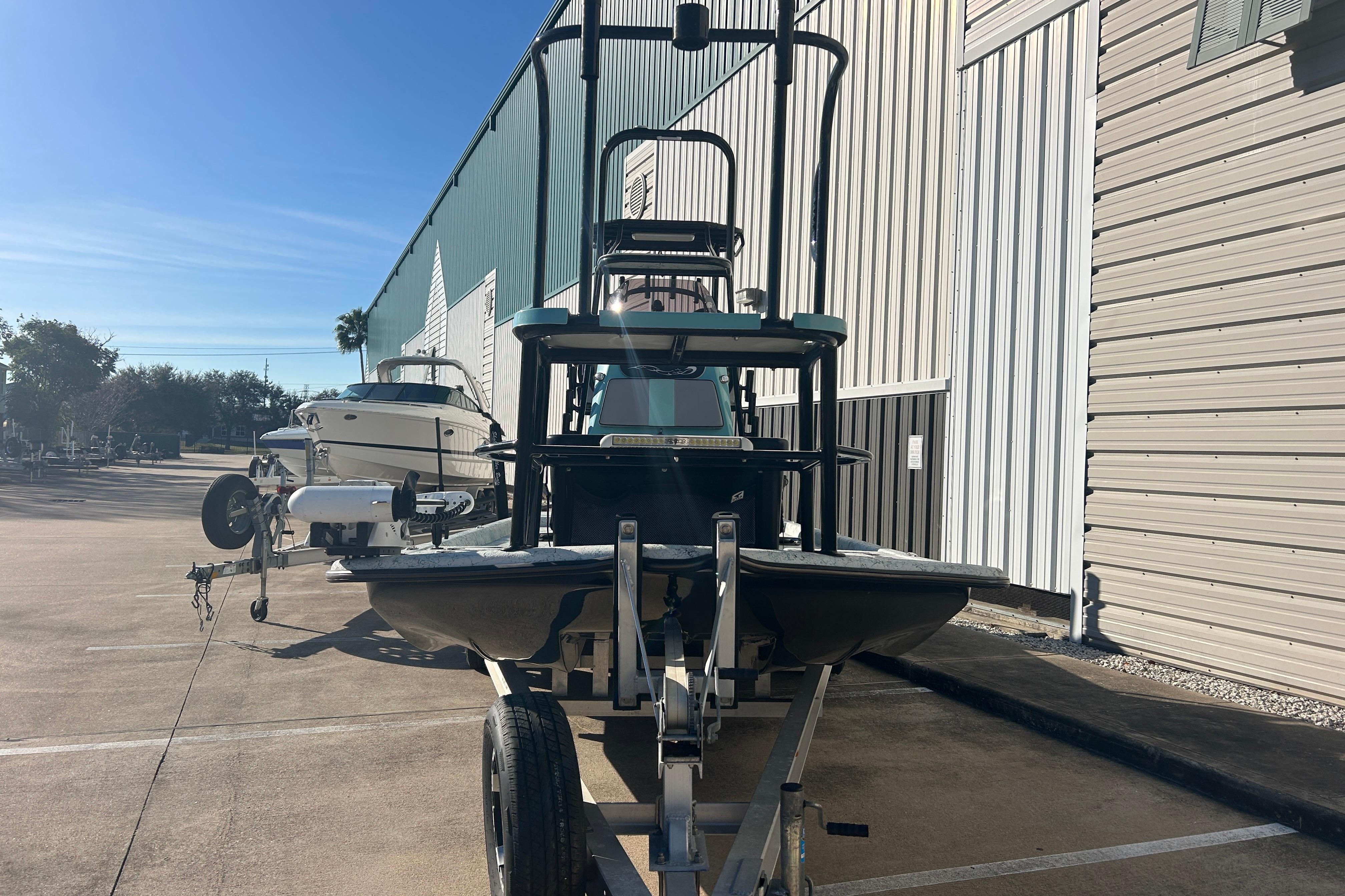 2021 Shallow Stalker Cat 240 Pro Elite boat on trailer, parked outside a warehouse.