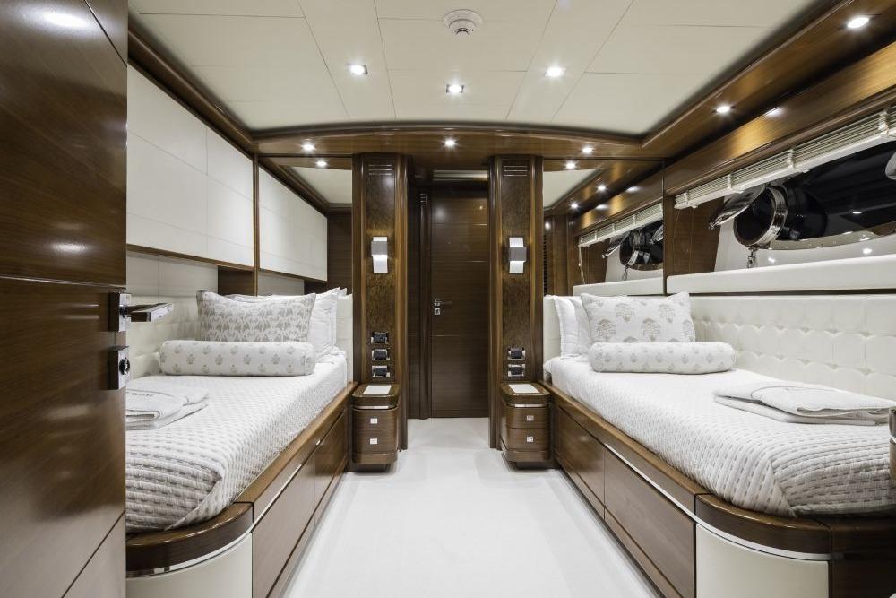 Luxurious CRN 129 yacht bedroom interior with twin beds, elegant wood finish, and modern lighting.