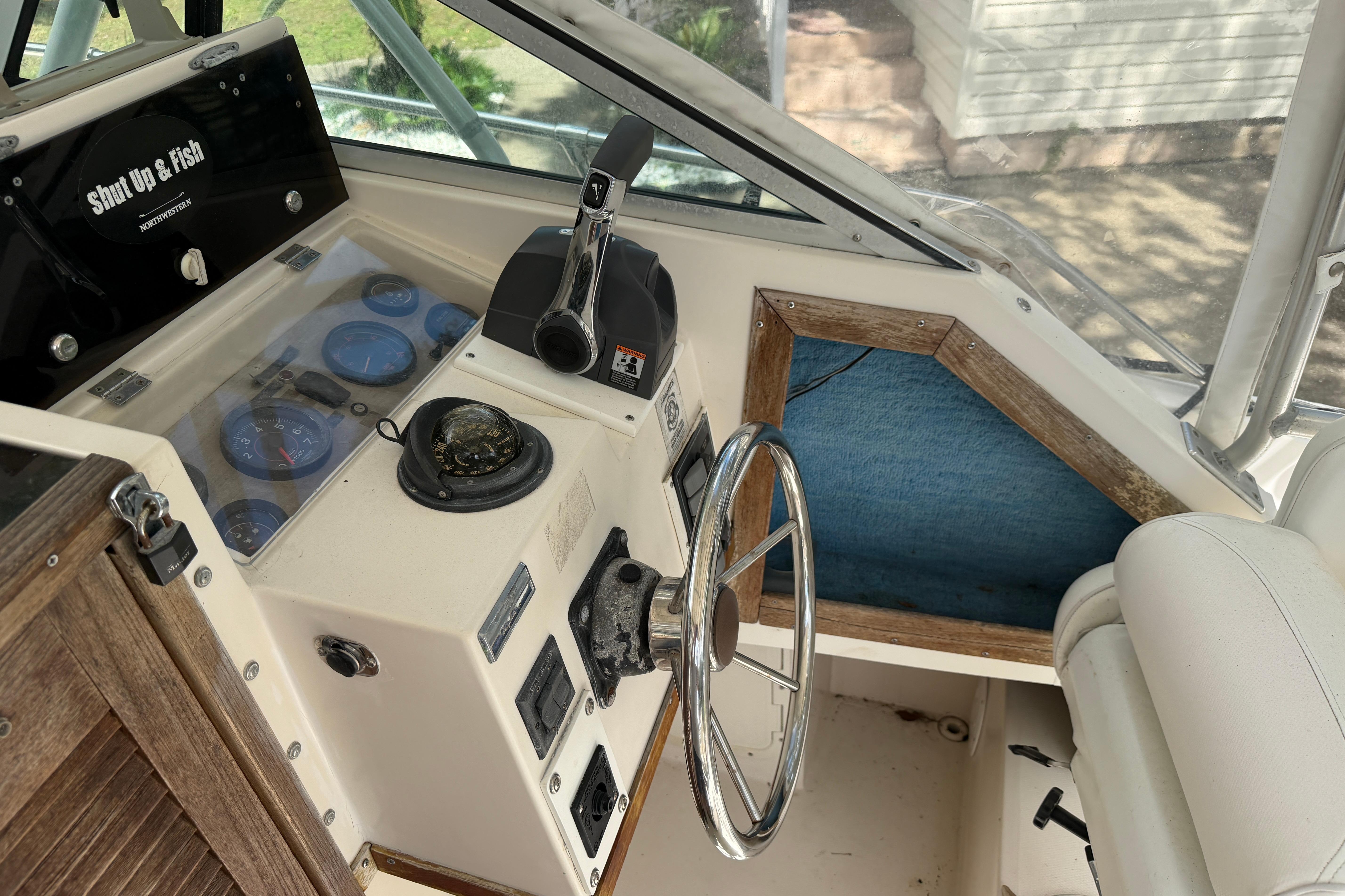 1987 Grady-White Seafarer 226 boat cockpit with steering wheel and control panel.