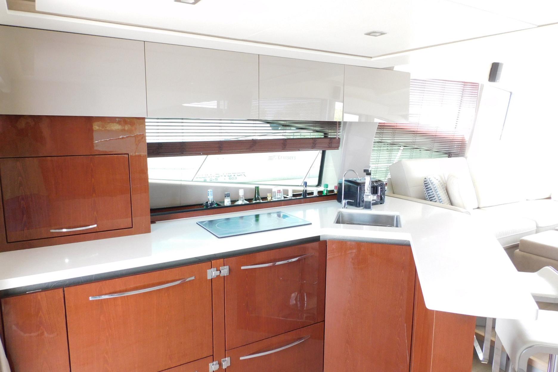 Luxurious kitchen interior of 2019 Sea Ray L550 yacht with modern cabinetry and appliances.