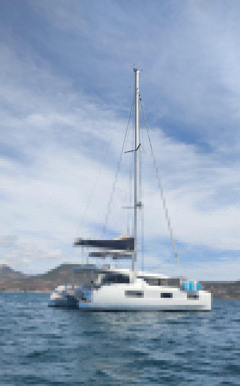 2020 Lagoon 46 catamaran sailing on calm waters under a cloudy sky.