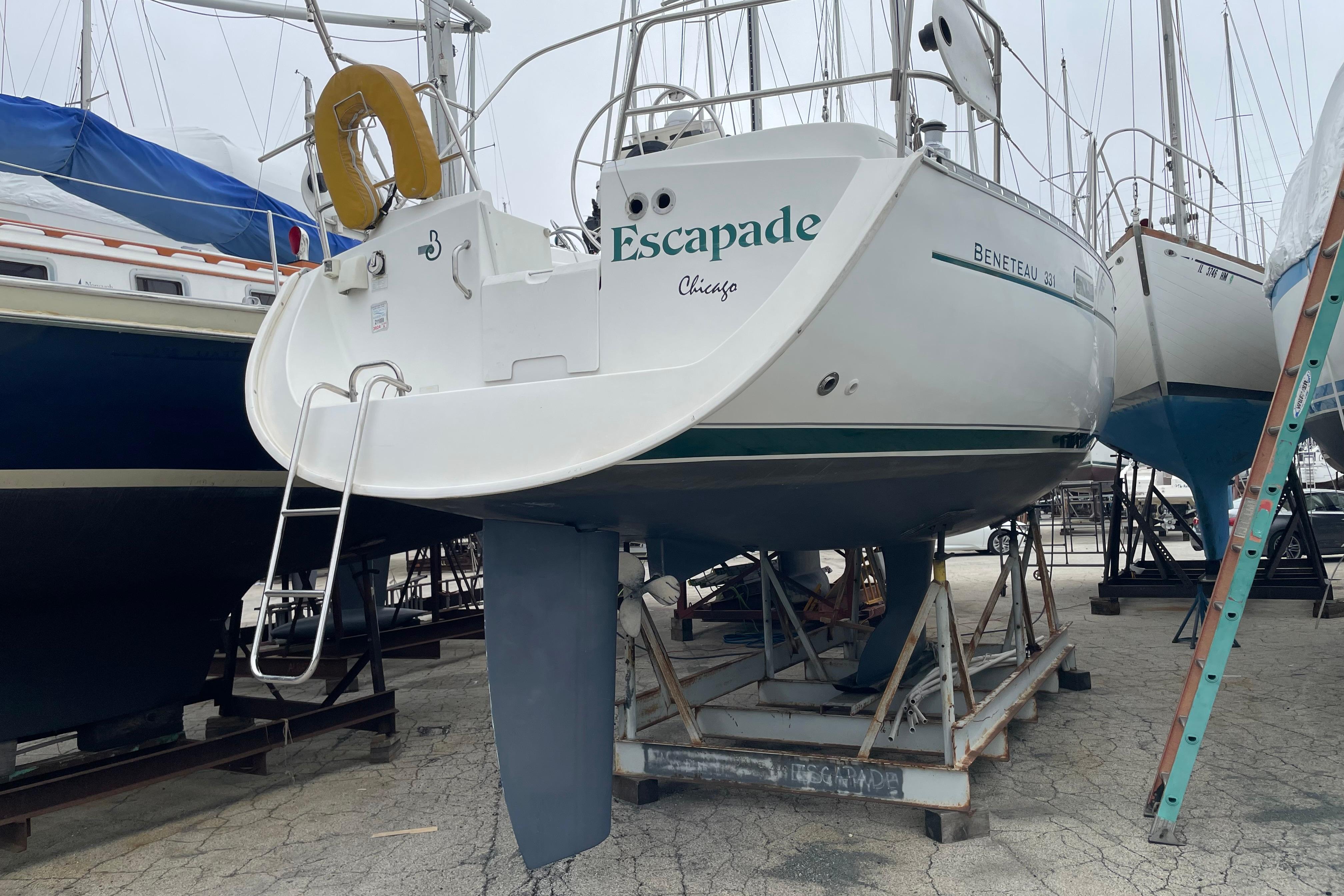2002 Beneteau 331 sailboat on dry dock, named "Escapade," with visible ladder and keel.
