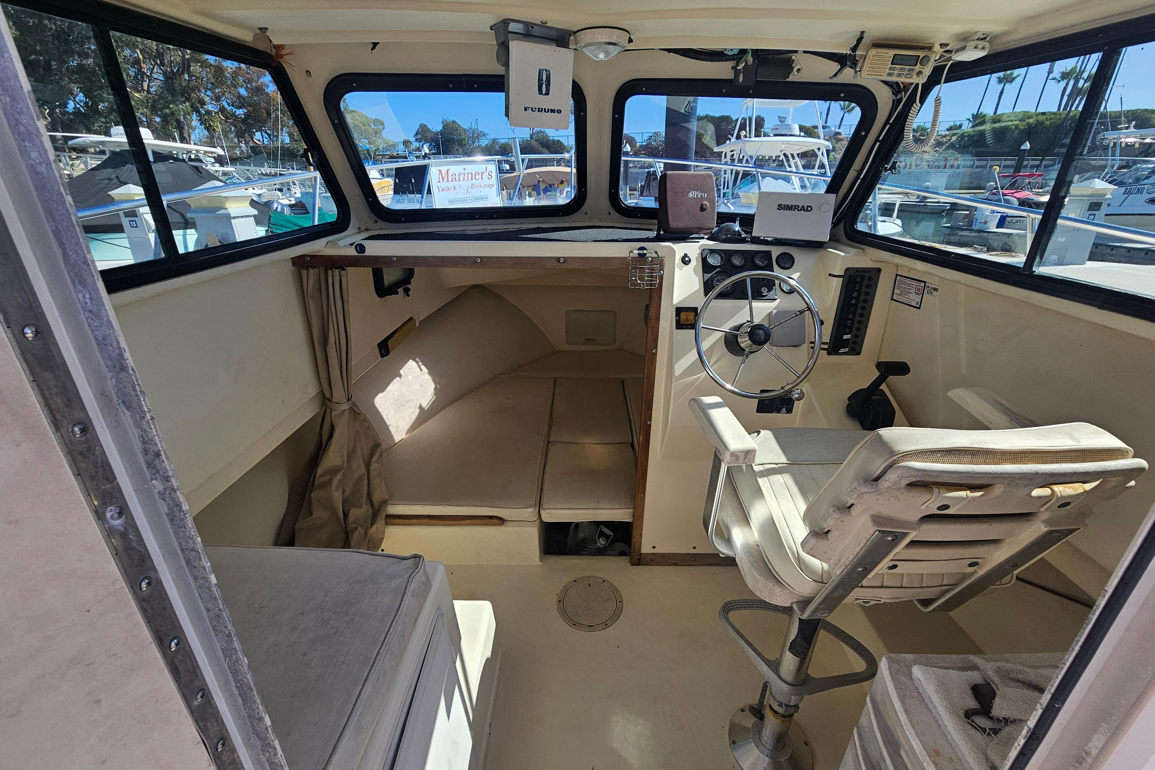 Interior of a 2000 Parker 2520 Sport Cabin boat with steering wheel and seating.