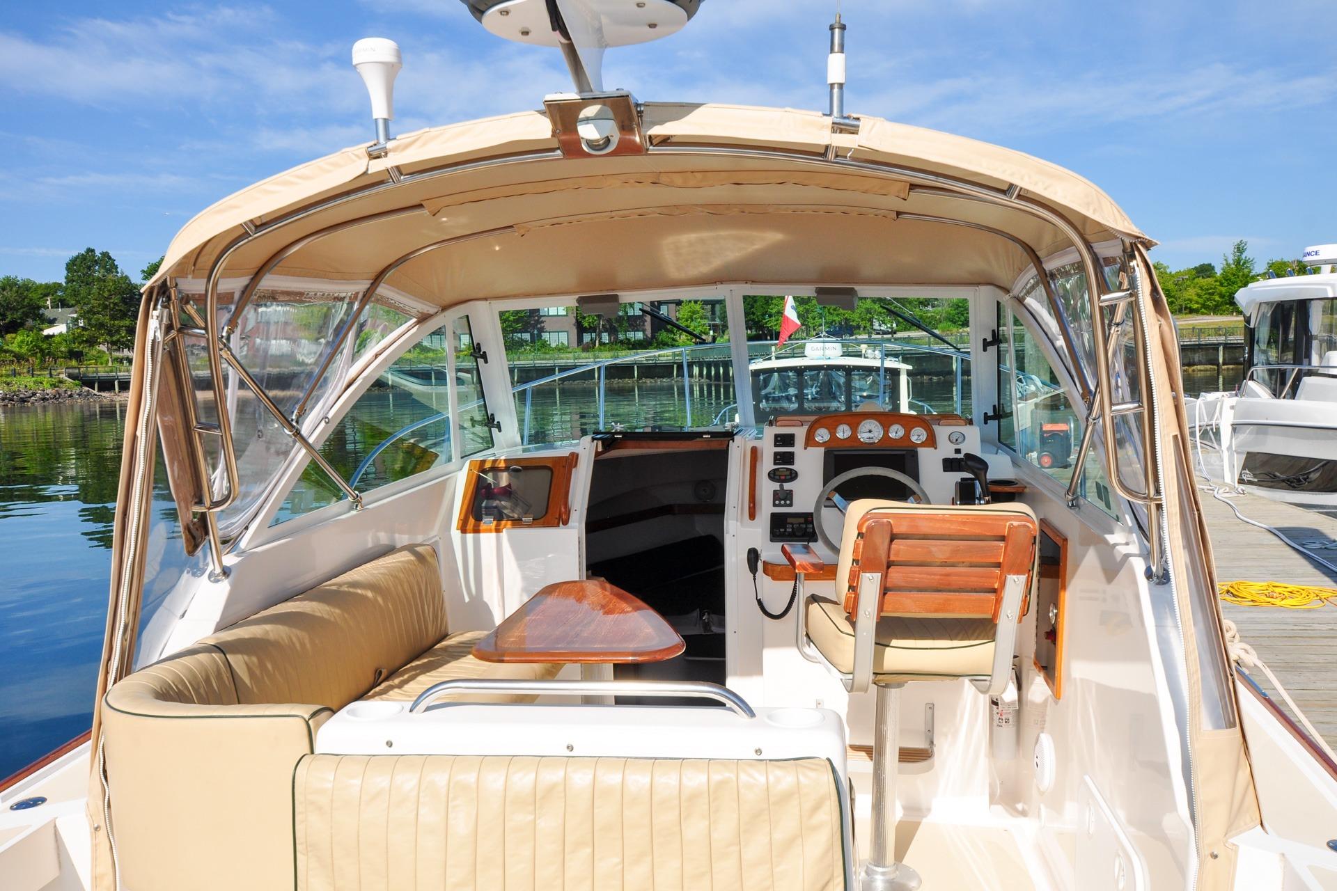 2005 Hunt Yachts Surfhunter 29 interior with helm, seating, and dock view.