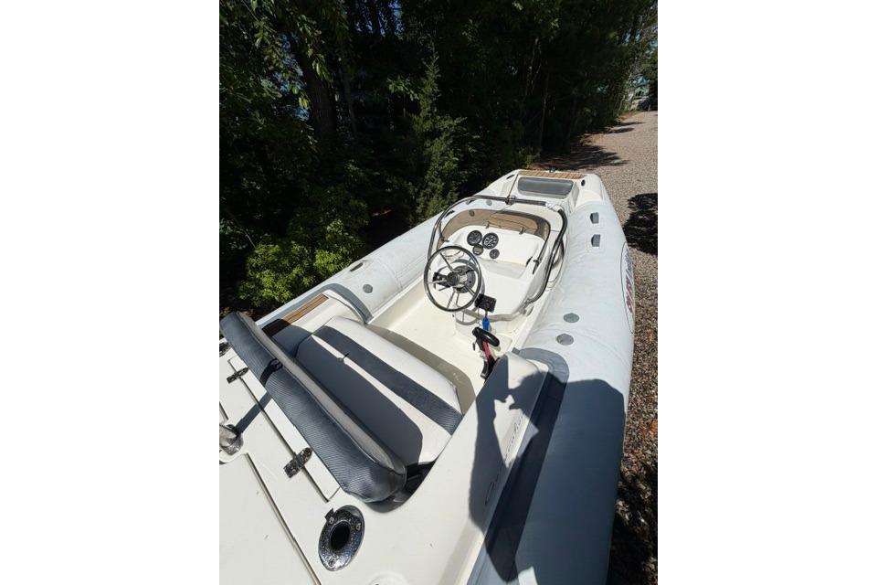 2016 Walker Bay Generation 450 DLX boat with steering wheel and seating, docked outdoors.