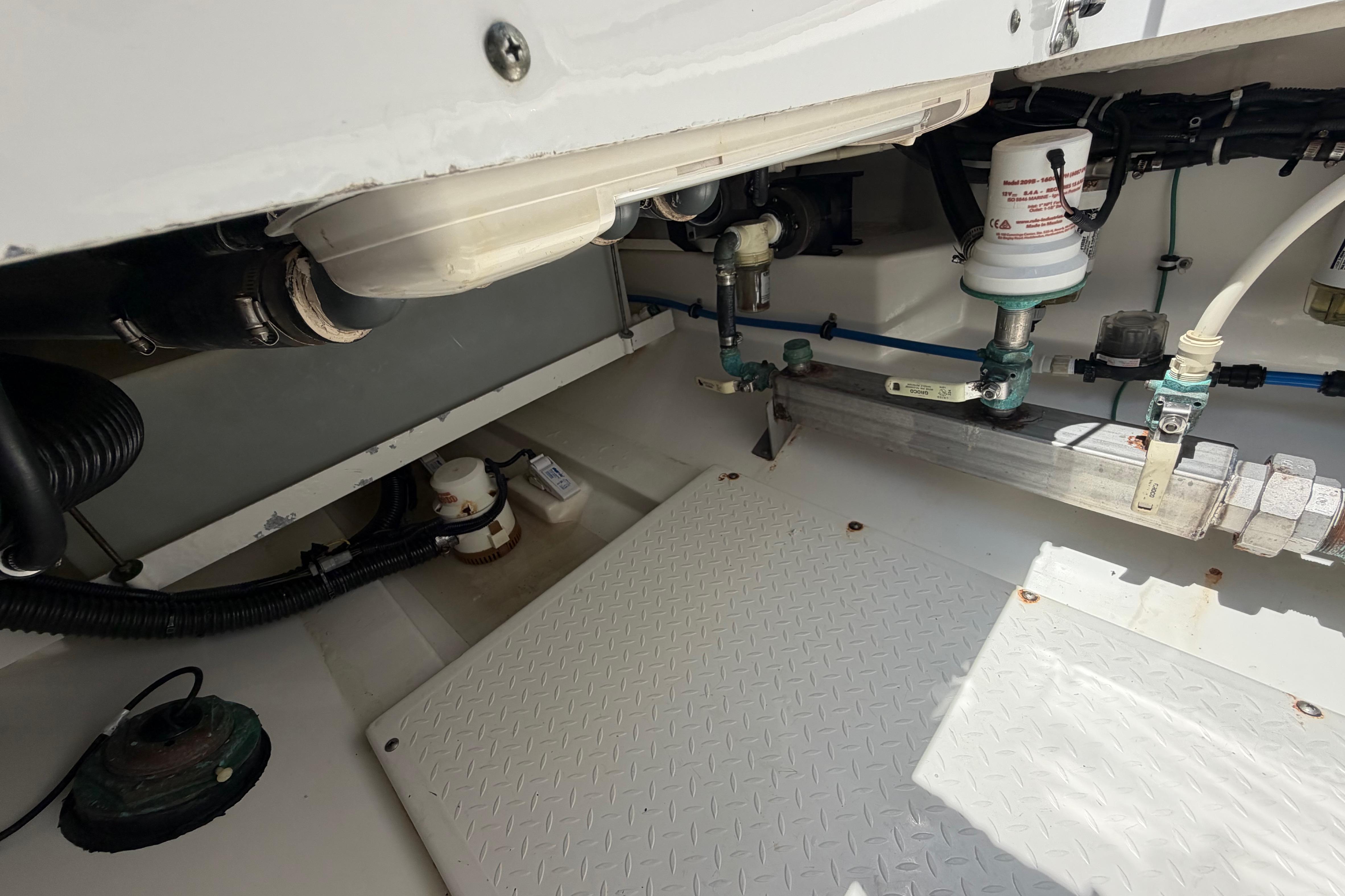 Engine compartment of a 2009 Everglades 350LX boat, showcasing mechanical components and piping.