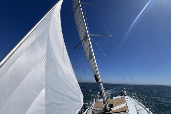 Sailing on a 2025 Hanse 360 yacht under clear blue skies.