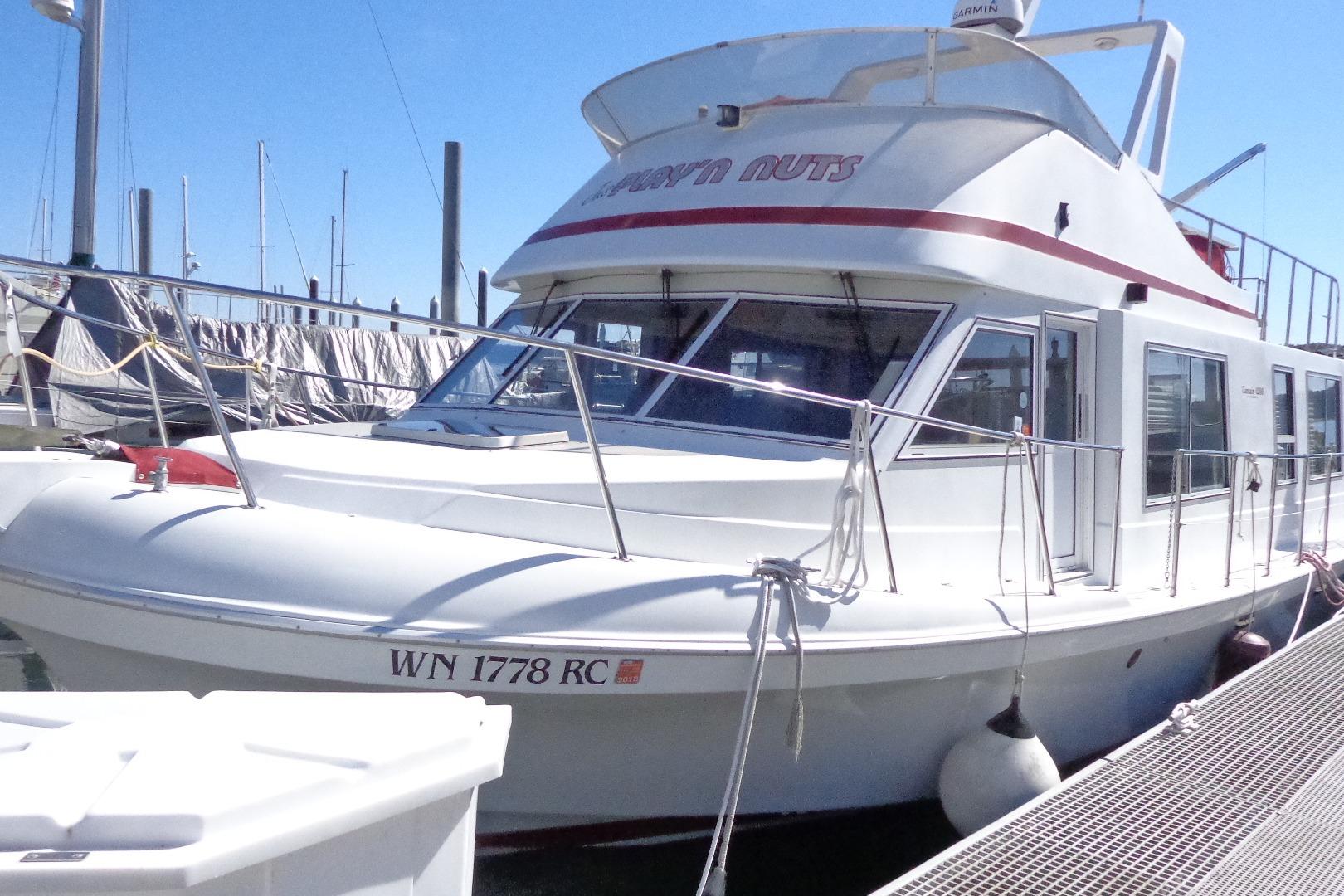 1992 Cruise-A-Home Corsair 4200 boat docked at marina under clear blue sky.