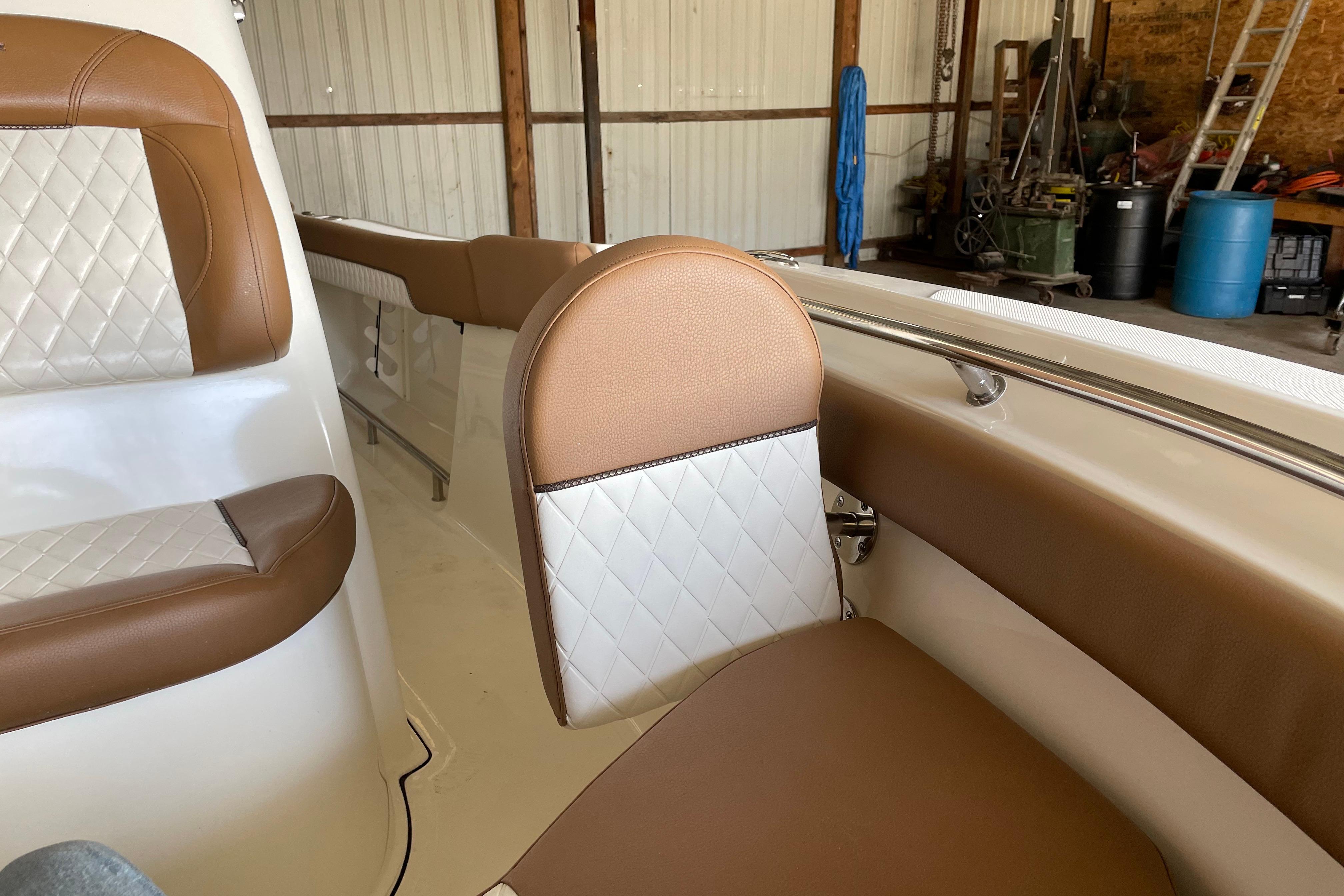 2026 Pioneer 202 Islander boat interior with brown and white cushioned seating.