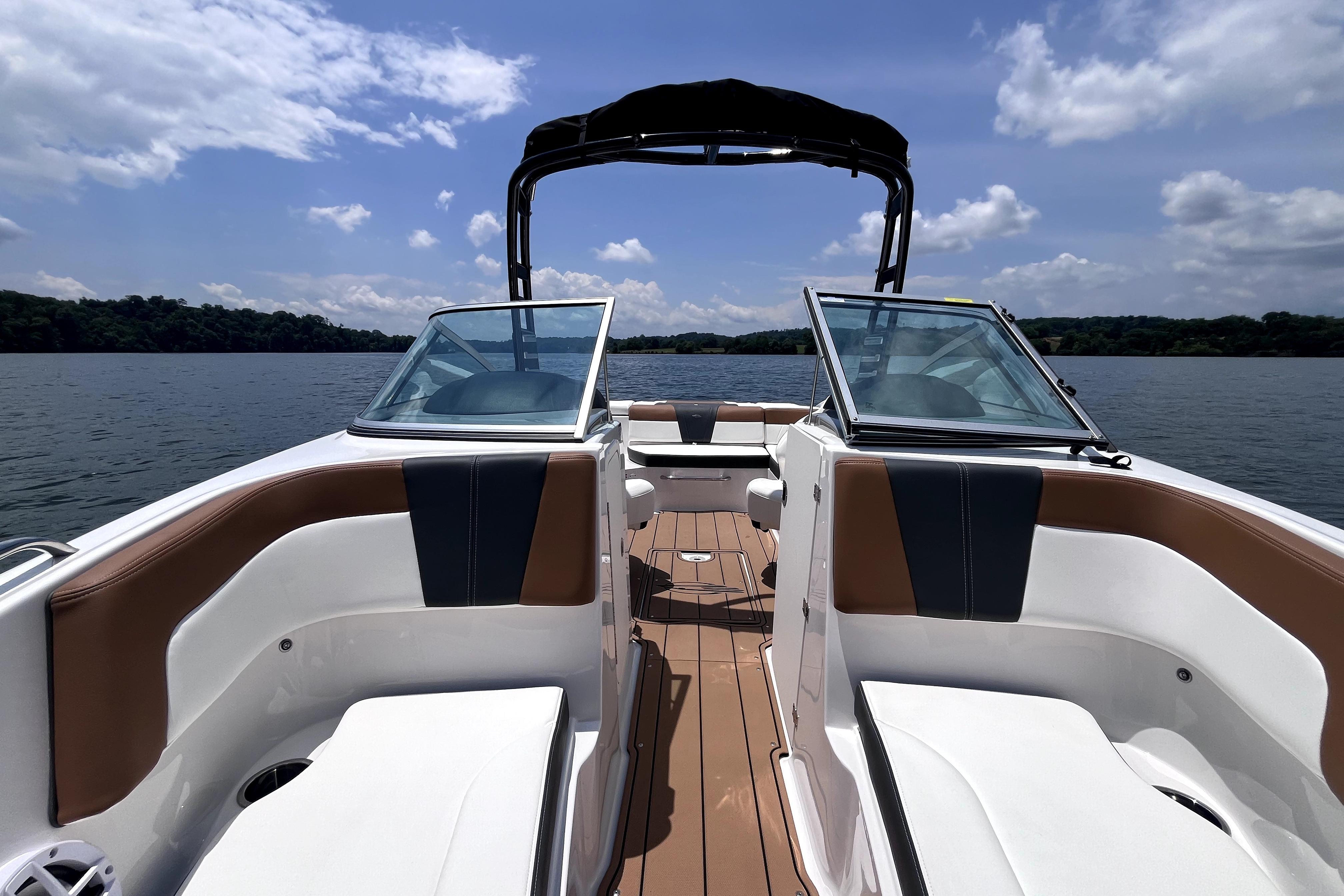 2025 Chaparral 230 SSi boat interior with open deck, on a serene lake.