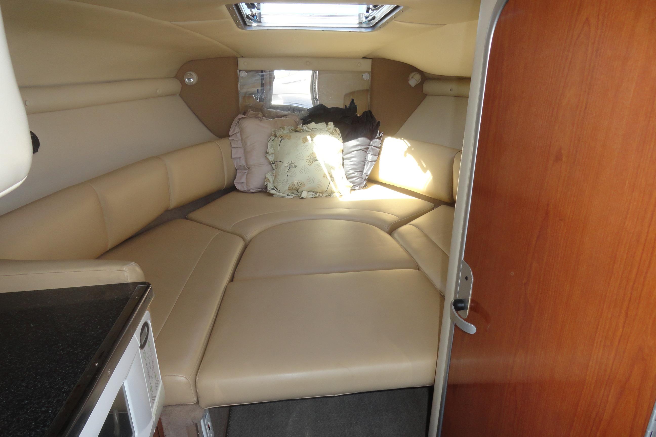 Interior cabin of 2001 Chaparral 265 SSi boat with beige seating and pillows.