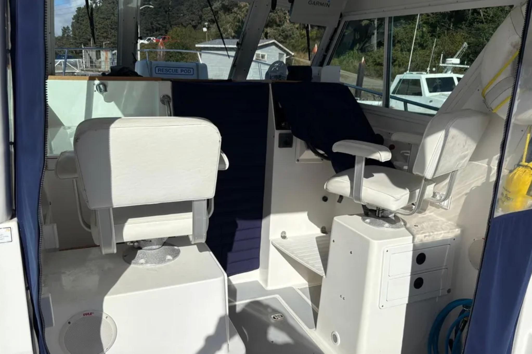 Interior of a 2005 Albin 28 Tournament Express boat with white seating and navigation equipment.