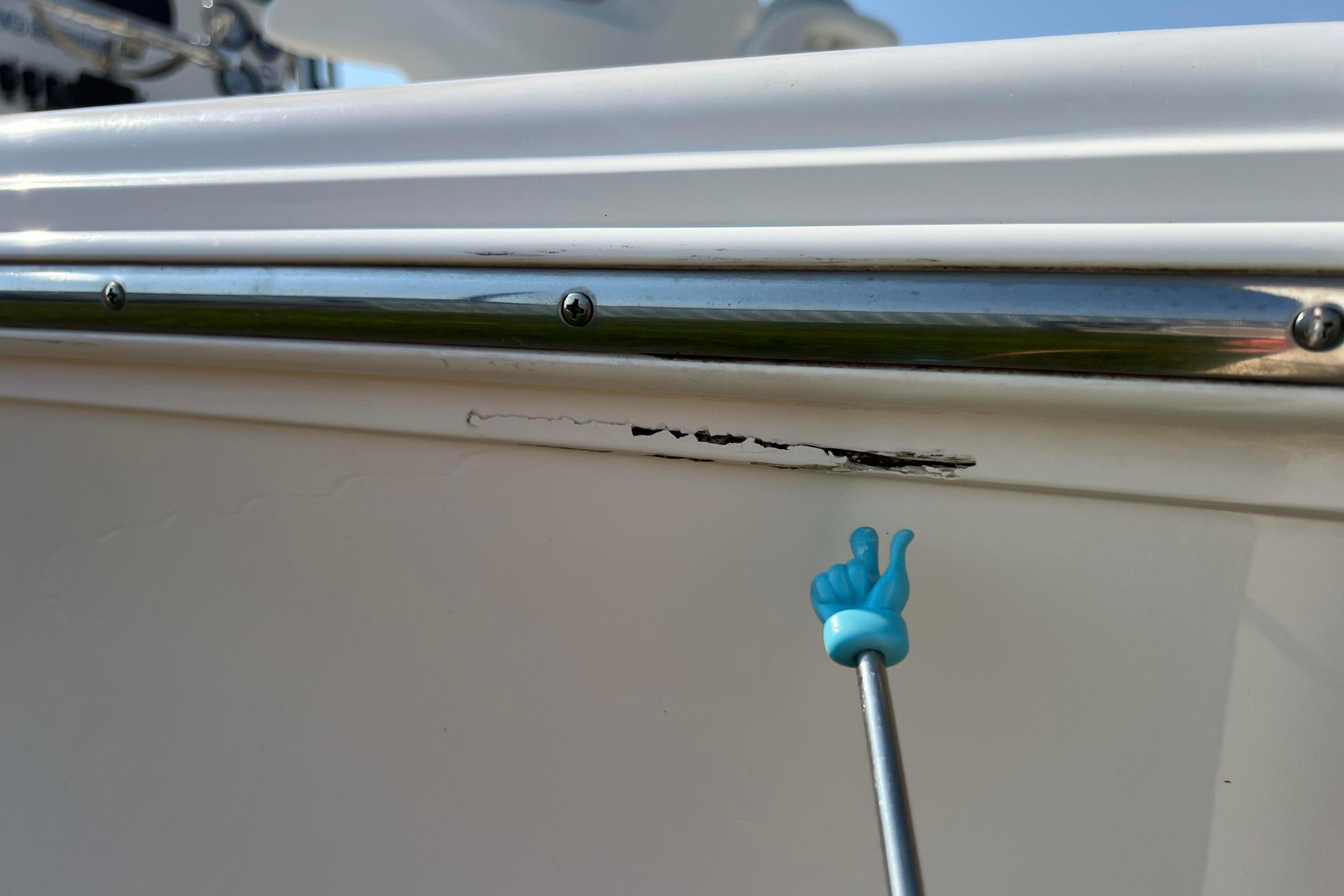 2012 Sea Fox 206 Center Console boat with minor hull scratch and metal railing.