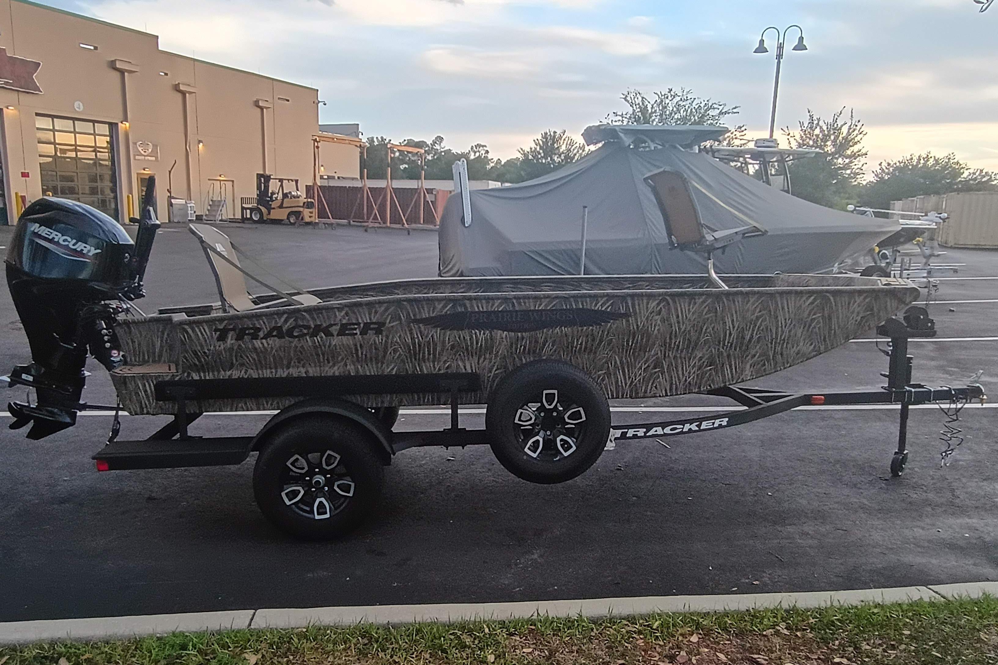 2026 Tracker Grizzly 1650 T Prairie Wings Edition boat on trailer, parked outdoors.