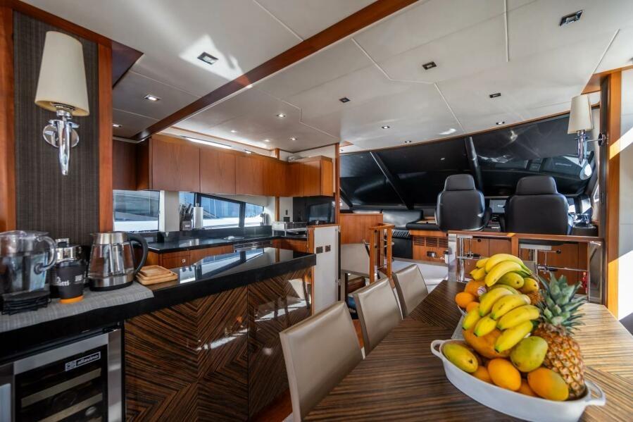Luxurious interior of 2015 Sunseeker 75 yacht with modern kitchen and dining area.
