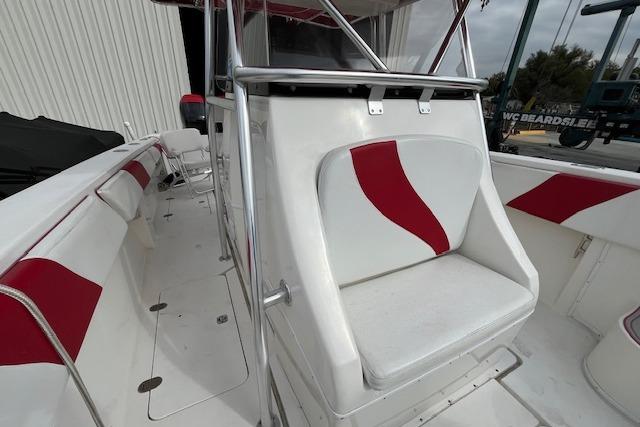 2001 Fountain 38 Center Console boat with red and white seating, docked outdoors.