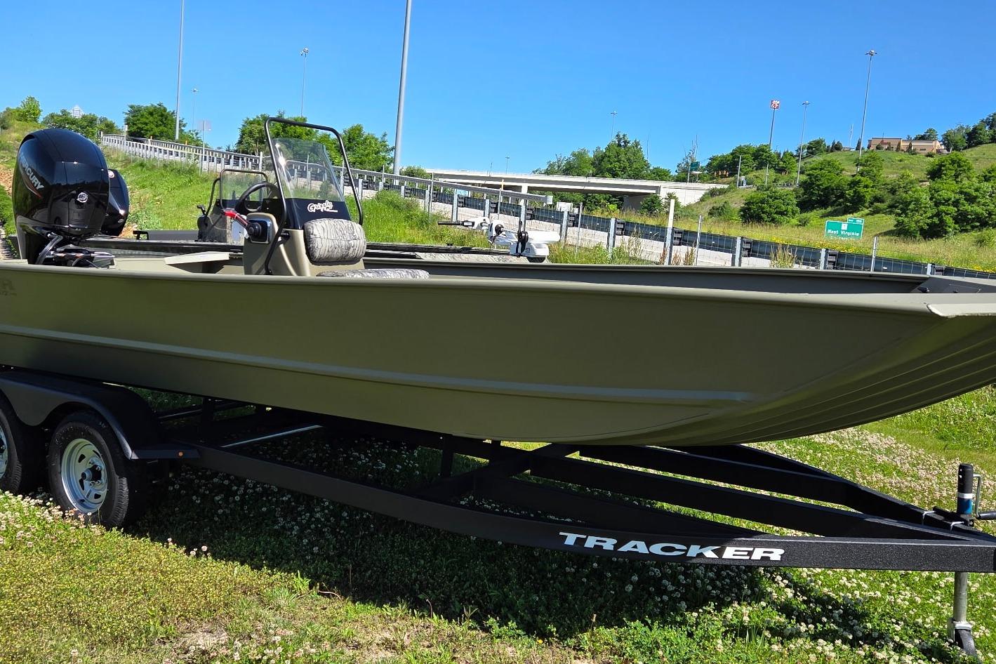 2026 Tracker Grizzly 2072 CC boat on trailer, parked outdoors.
