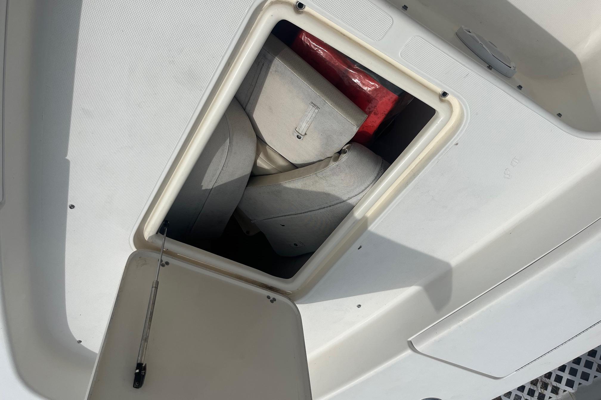 Open storage compartment on 2009 Scout 221 Winyah Bay boat, showing life jackets inside.