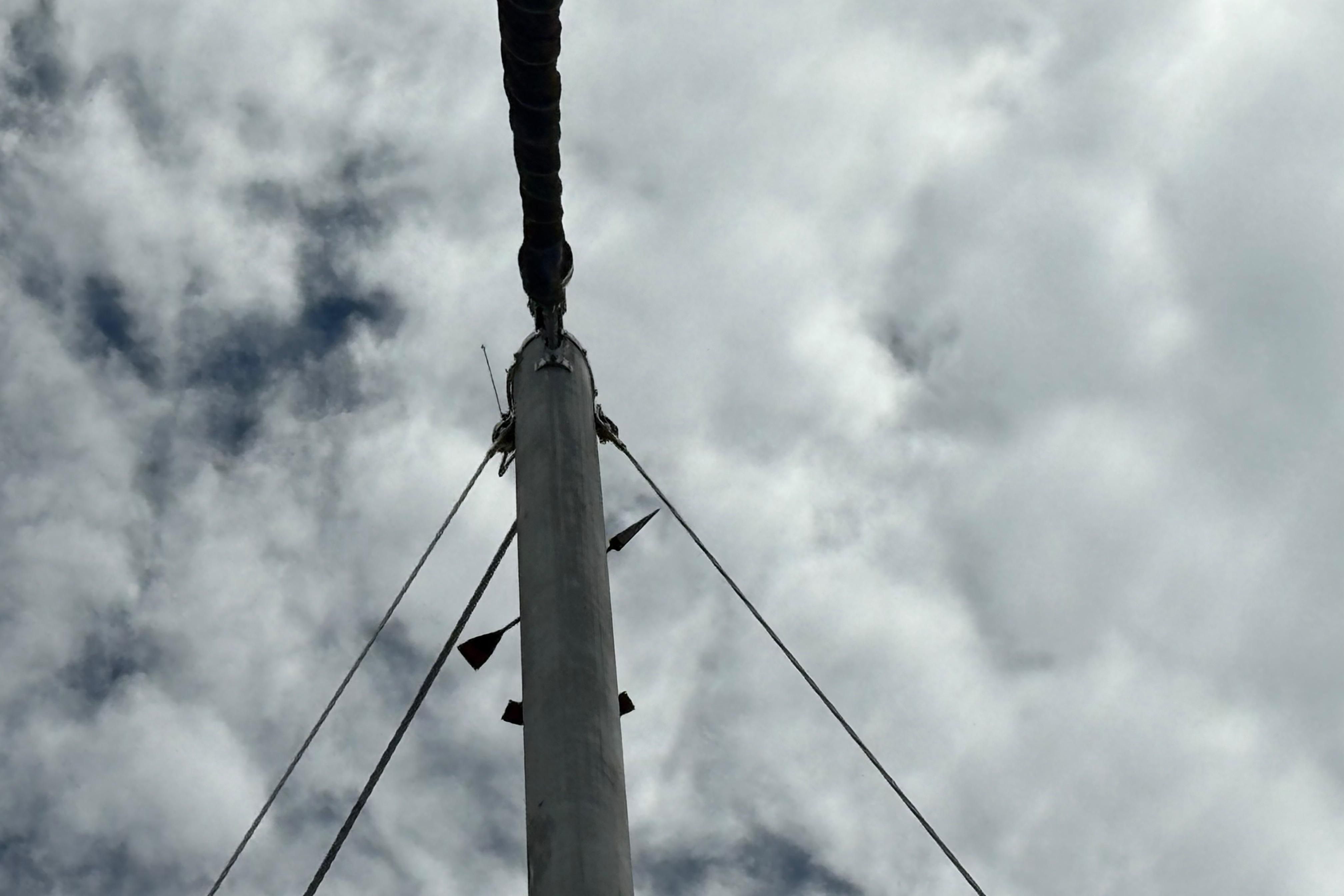 Mast of 1981 Sabre 31 sailboat against cloudy sky background.