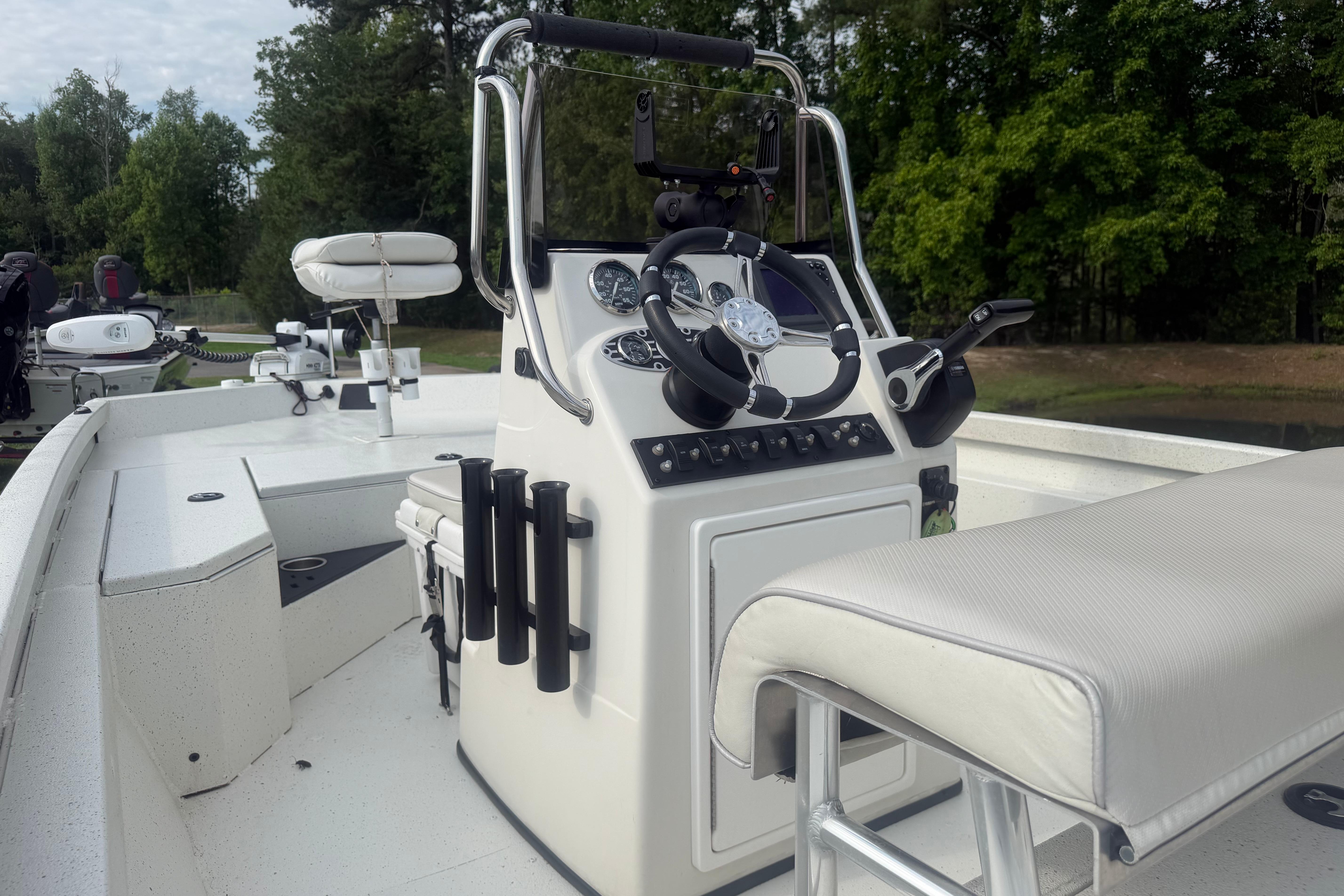 2018 Ranger RB190 boat interior with steering console and seating, surrounded by lush greenery.