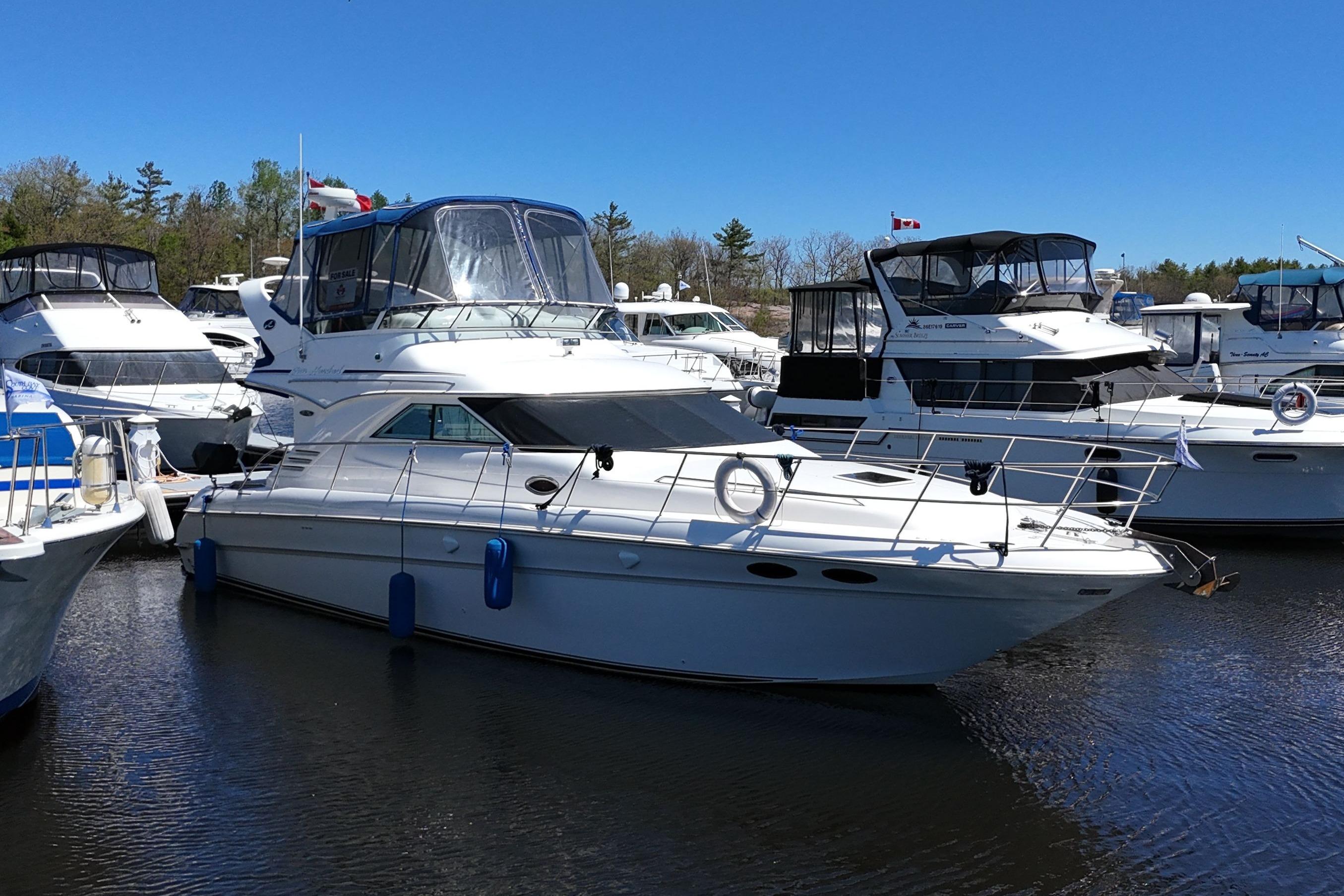 2001 Sea Ray 400 Sedan Bridge yacht docked in a marina under clear blue skies.