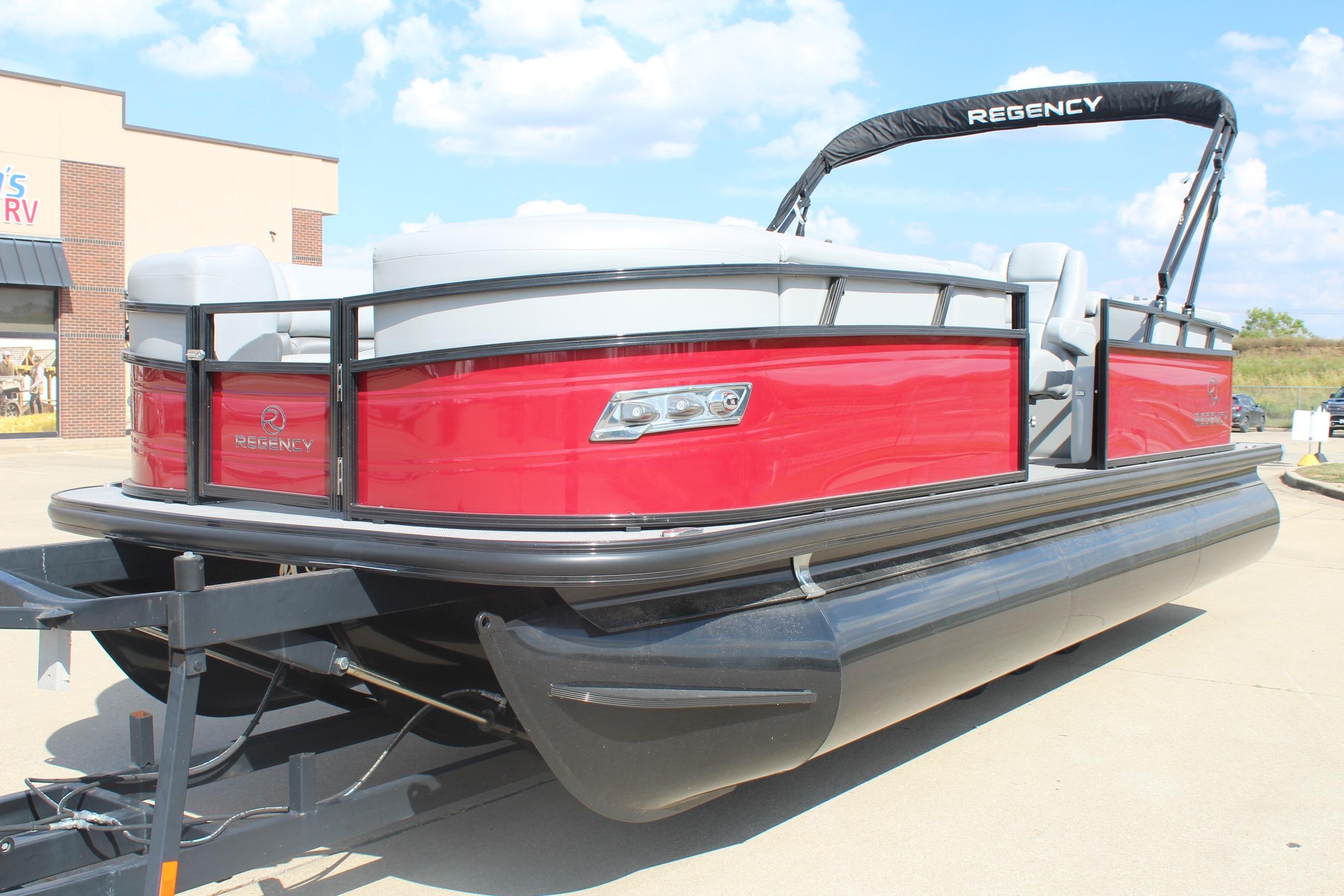 2025 Regency 230 DL3 pontoon boat with red exterior on a trailer.