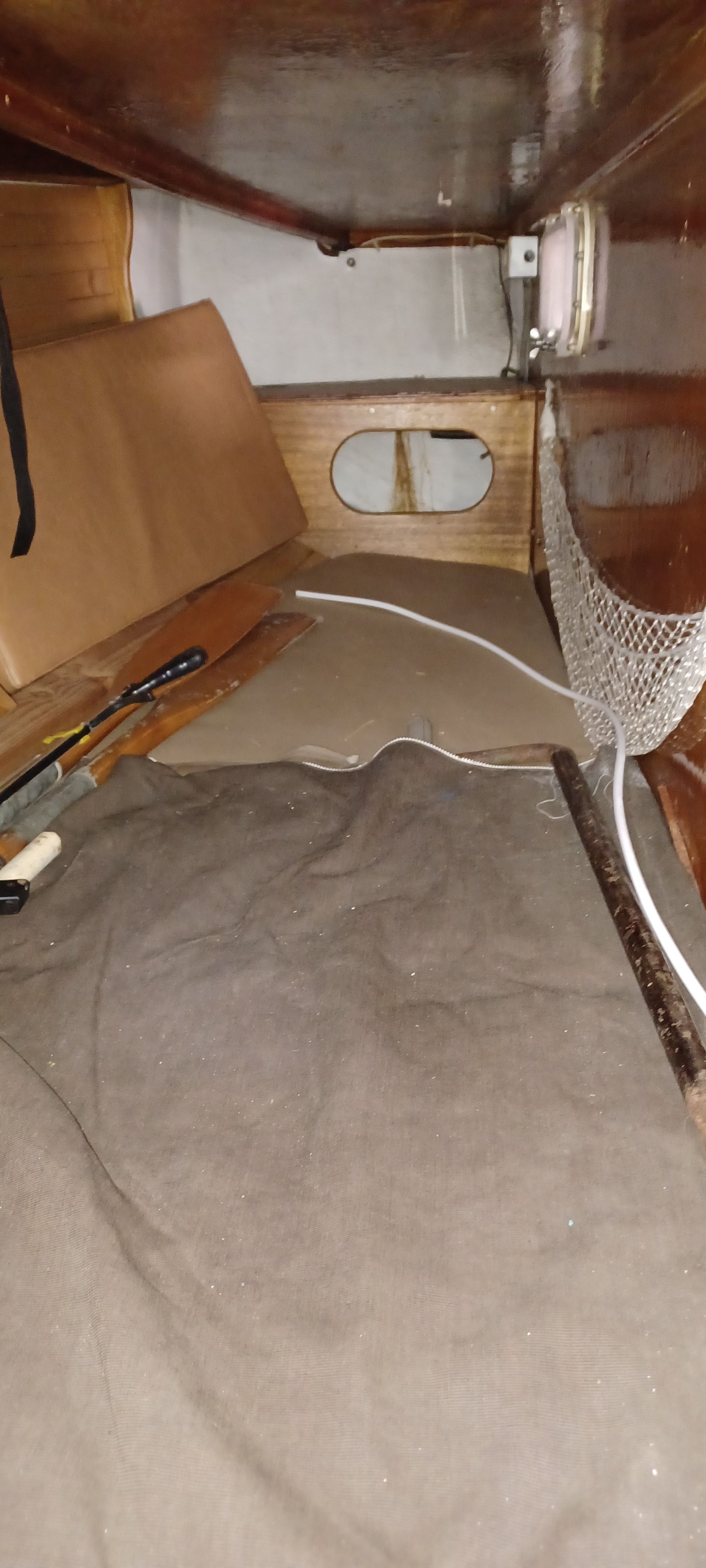 Interior of a boat with wooden paneling and a netted pocket.