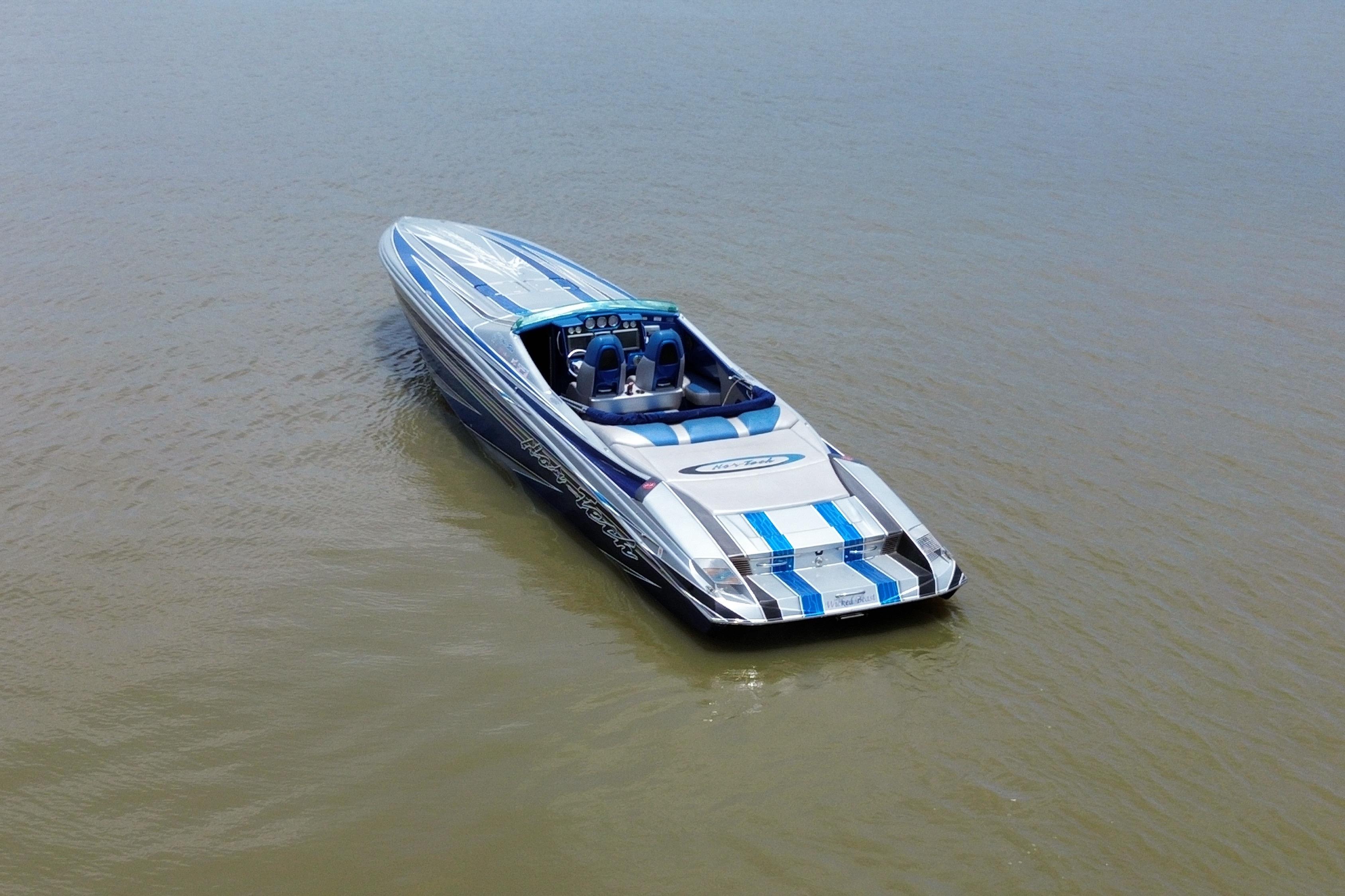 2013 Nor-Tech 477 SPX Vee Bottom boat on calm water, featuring sleek blue and white design.