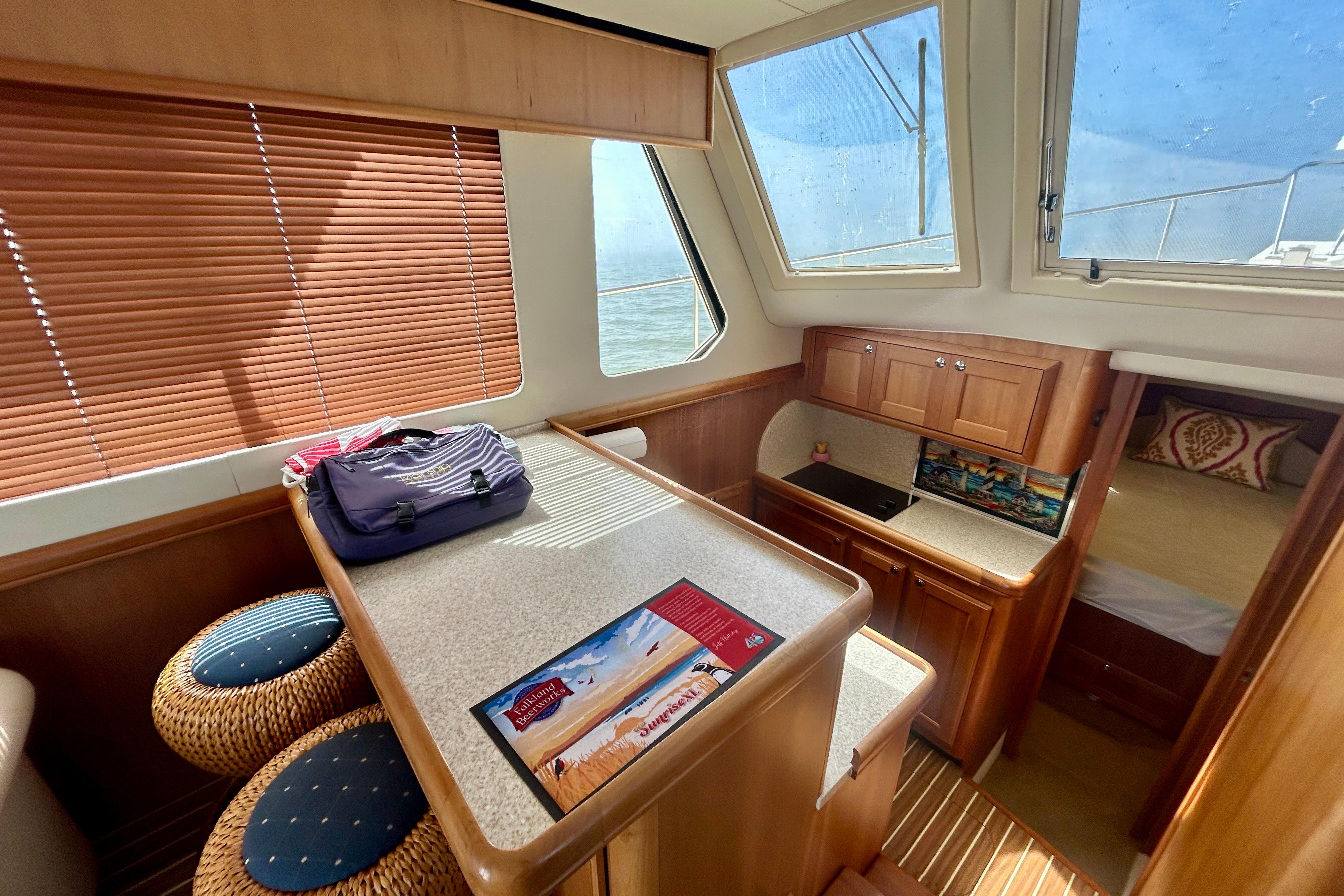 Interior of 2006 Mainship 34 Trawler with kitchen, seating, and bedroom area.