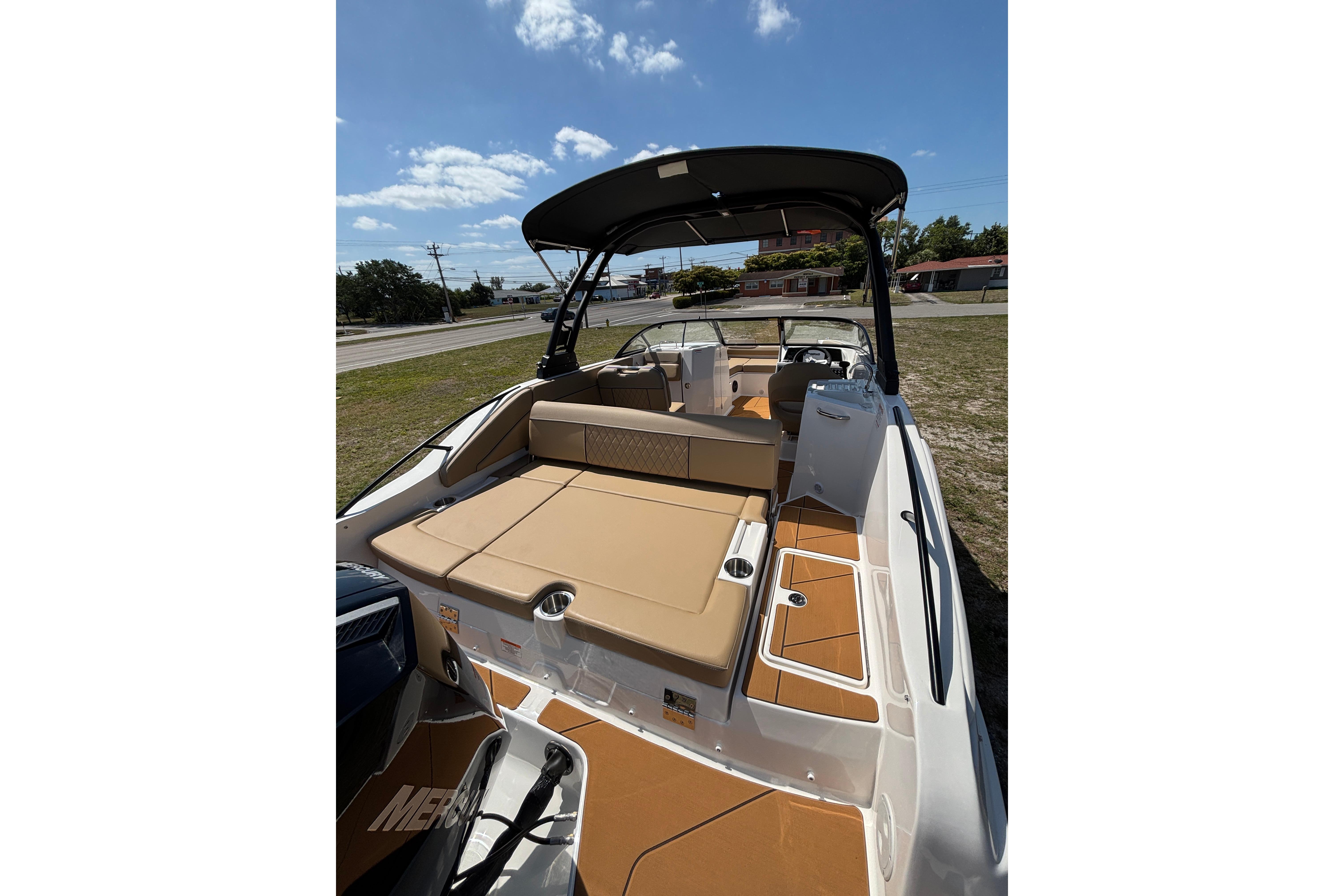 2026 Bayliner D22 boat with tan seating and sleek design under a sunny sky.